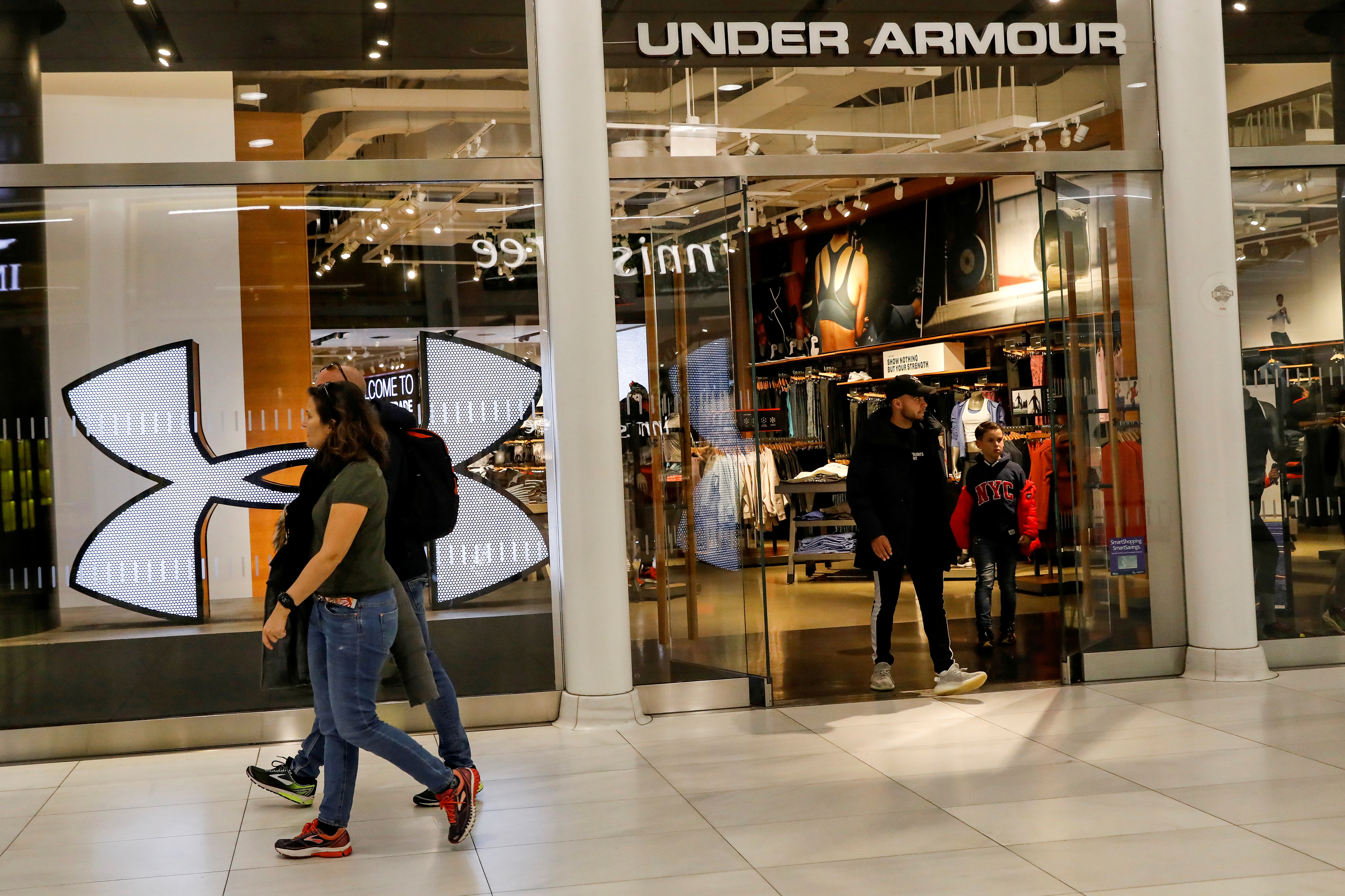 FILE PHOTO: Customers exit an Under Armour store in New York