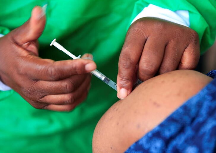 A nurse vaccinates a health worker against the coronavirus disease (COVID-19), in Harare