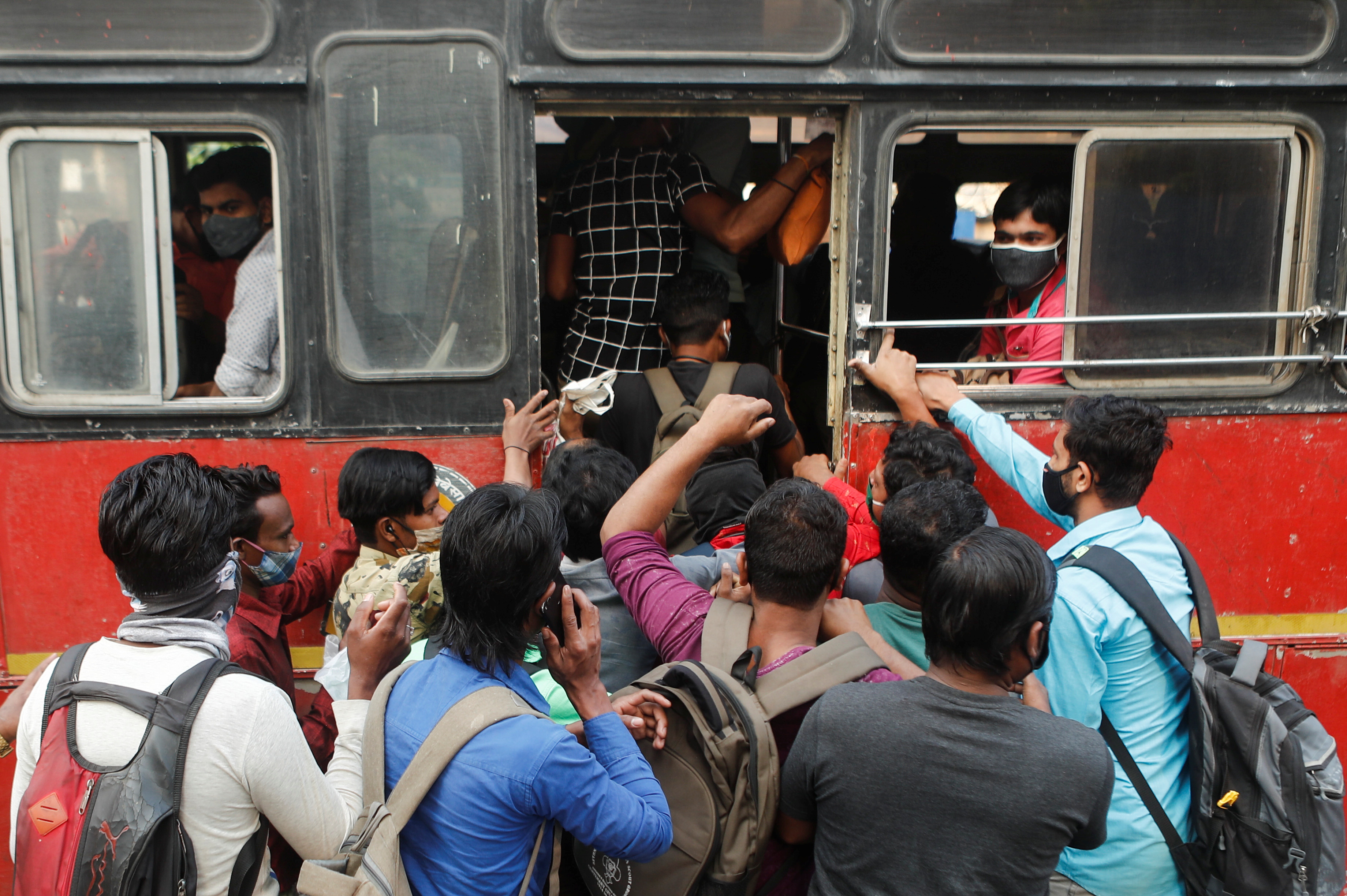 People scramble to board a bus amidst the spread of the coronavirus disease (COVID-19), in Mumbai, India, February 25, 2021. REUTERS/Francis Mascarenhas