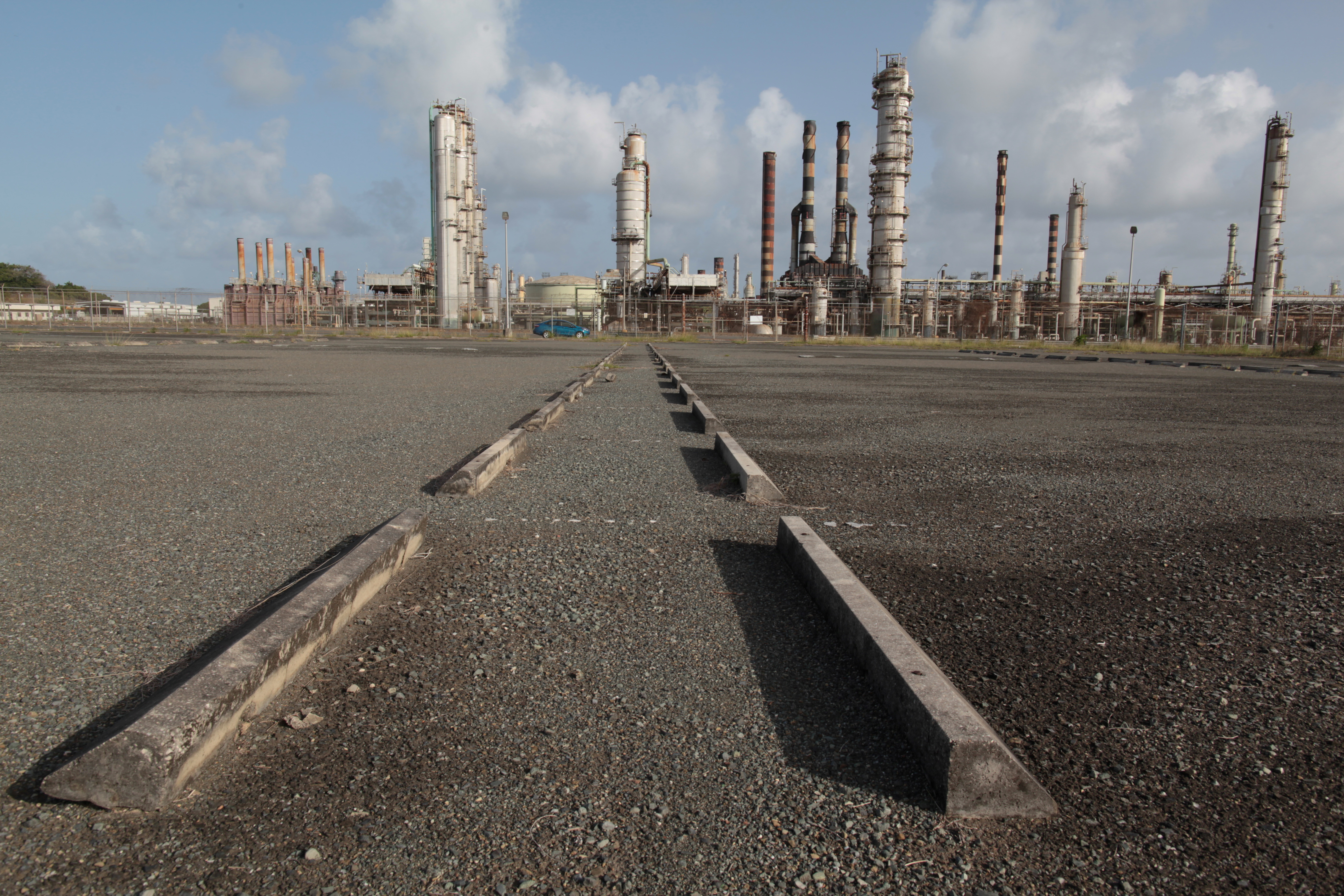 An abandoned parking lot is seen outside the installations of the Hovensa petroleum refinery in St Croix