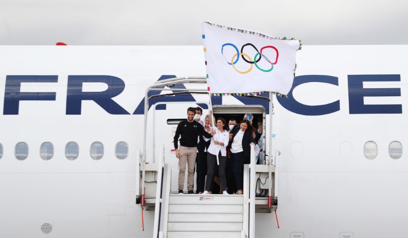 Olympics - French Olympic medallists arrive with the Olympic flag in Paris - Roissy Charles de Gaulle airport, Paris, France - August 9, 2021 Mayor of Paris Anne Hidalgo poses as she waves the Olympic flag with President of the Paris 2024 Organising Committee Tony Estanguet while French Olympic medallists arrive at Roissy Charles de Gaulle airport REUTERS/Sarah Meyssonnier