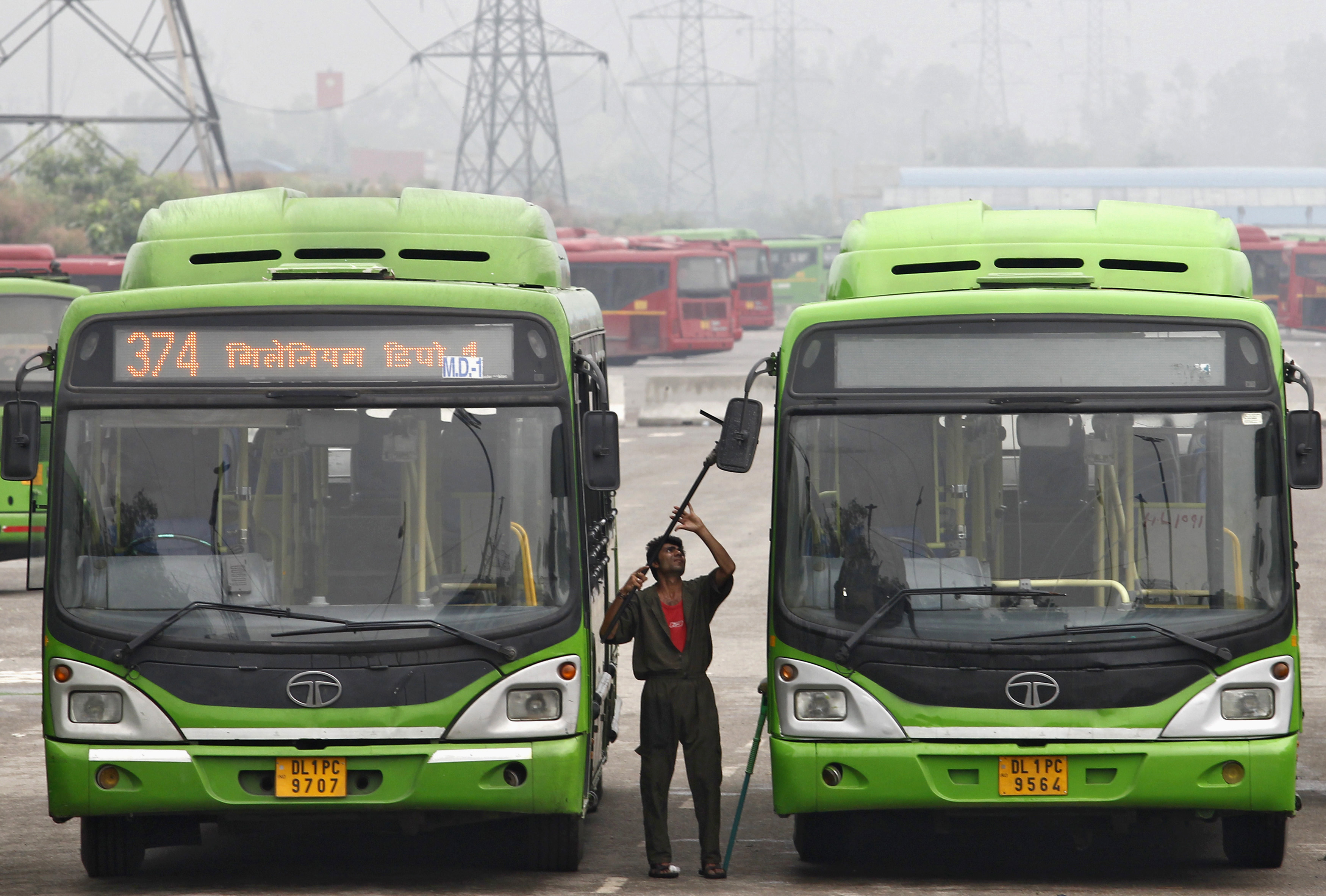 Worker cleans Tata Motors passenger bus at a depot in New Delhi