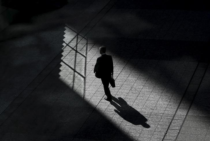 A man walks on a street between buildings at a business district in Tokyo