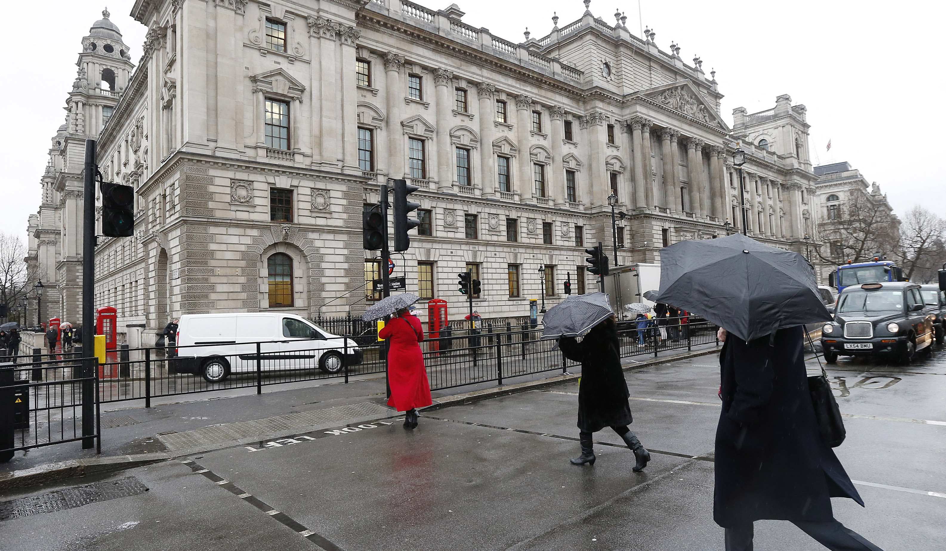 Pedestrians walk past the HM Revenue & Customs building in Whitehall, central London