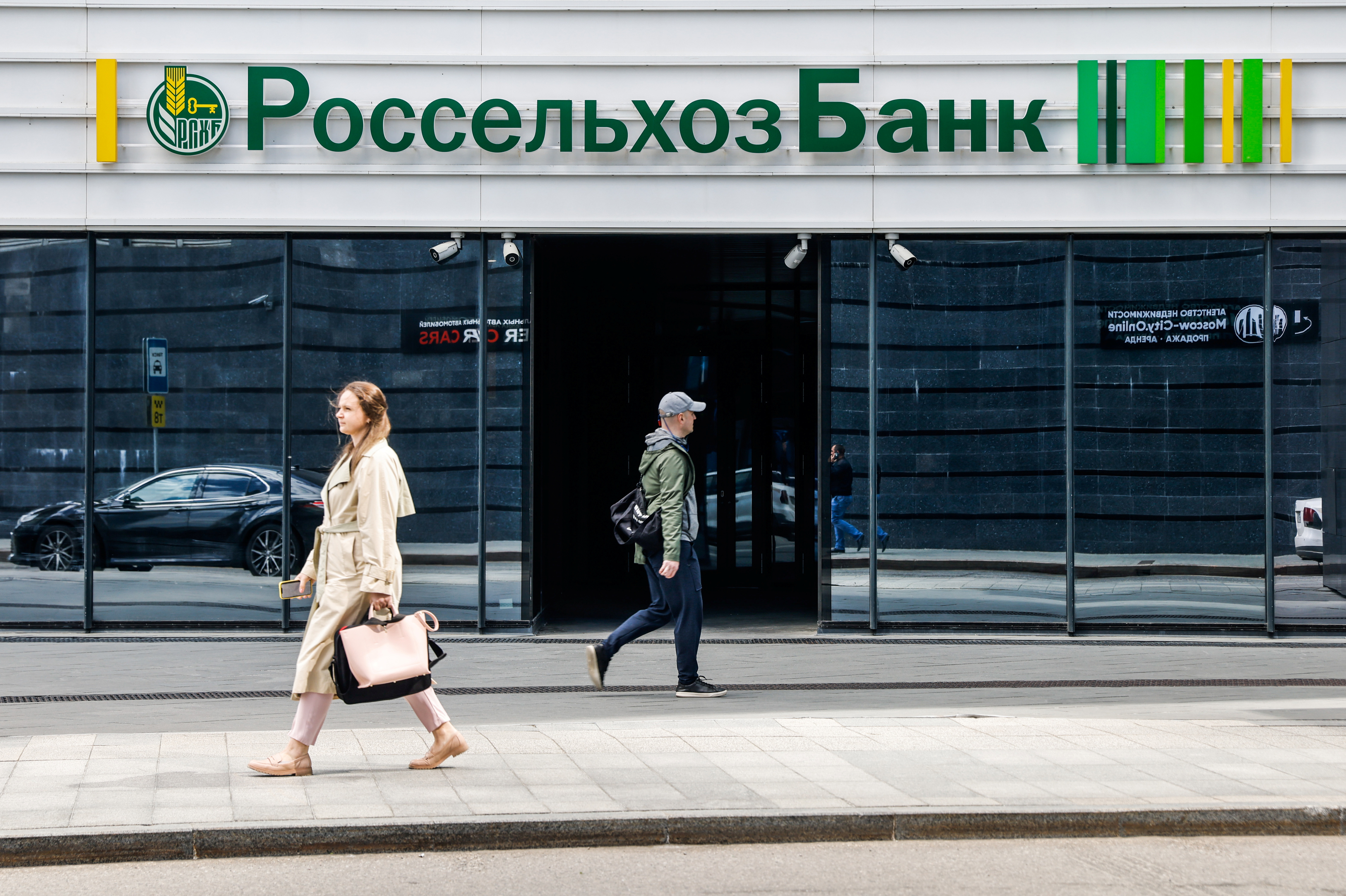 People walk past Rosselkhozbank office in Moscow
