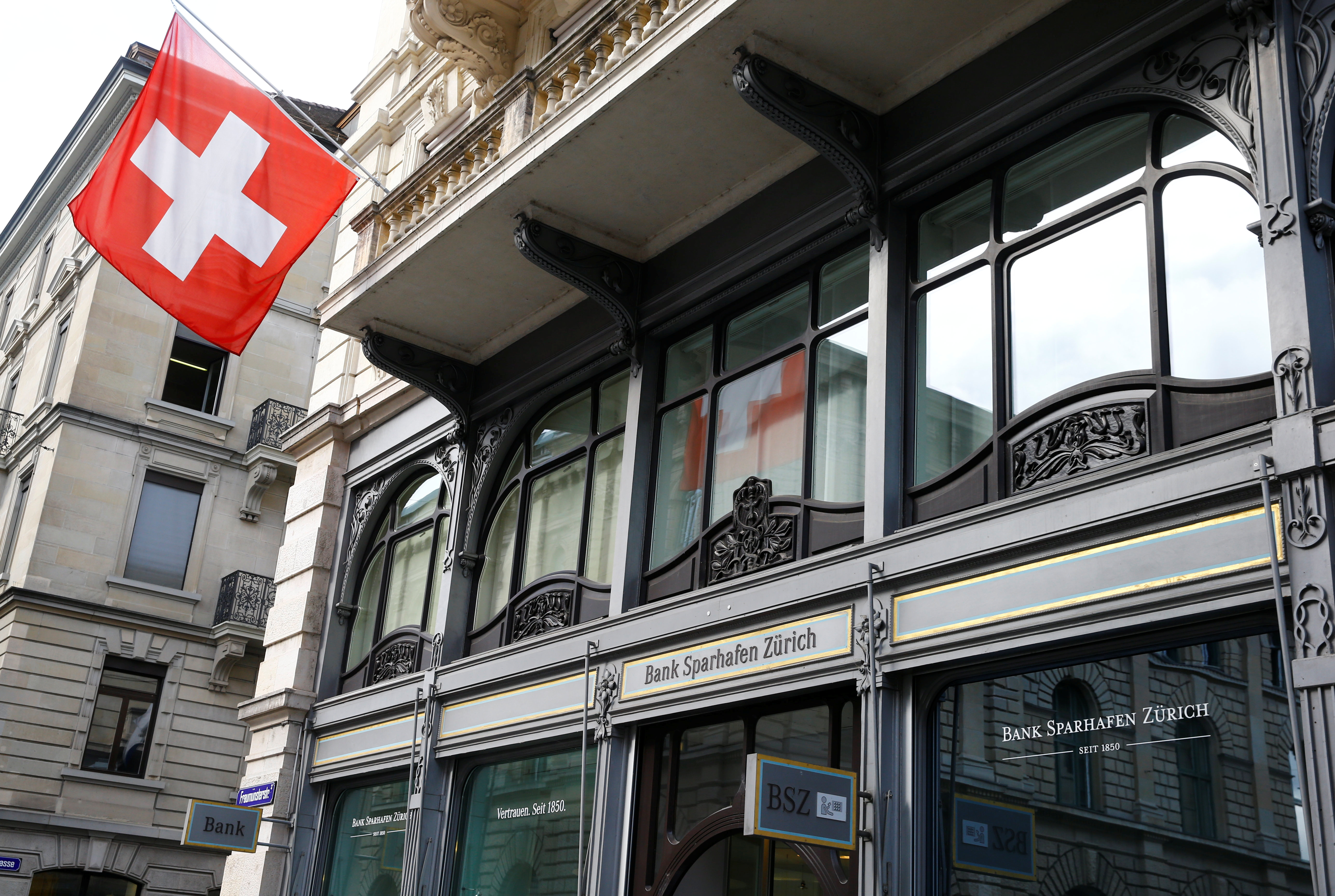 Switzerland's national flag flies at the headquarters of Swiss bank Bank Sparhafen Zuerich in Zurich