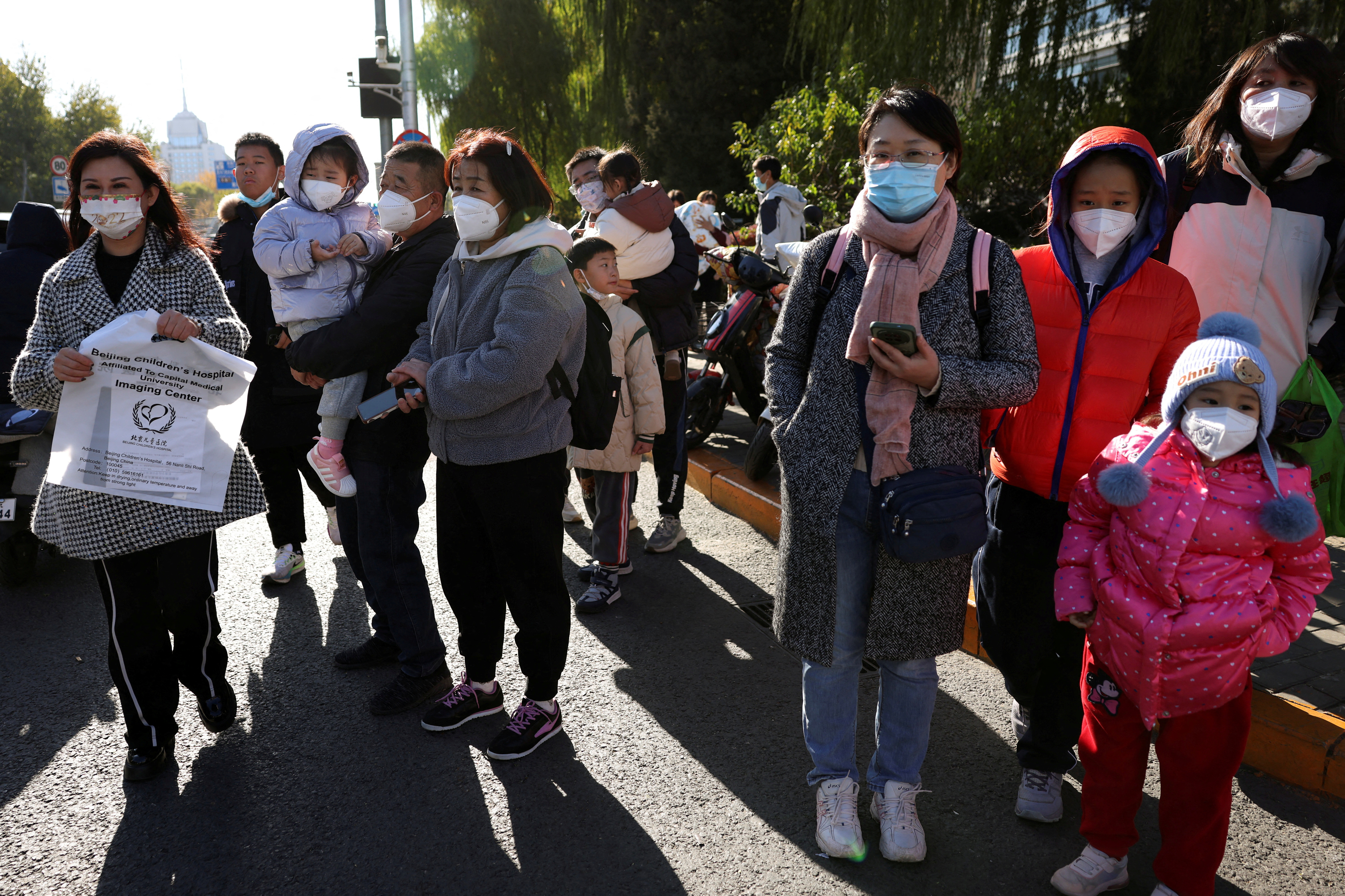 People wait outside a children's hospital in Beijing