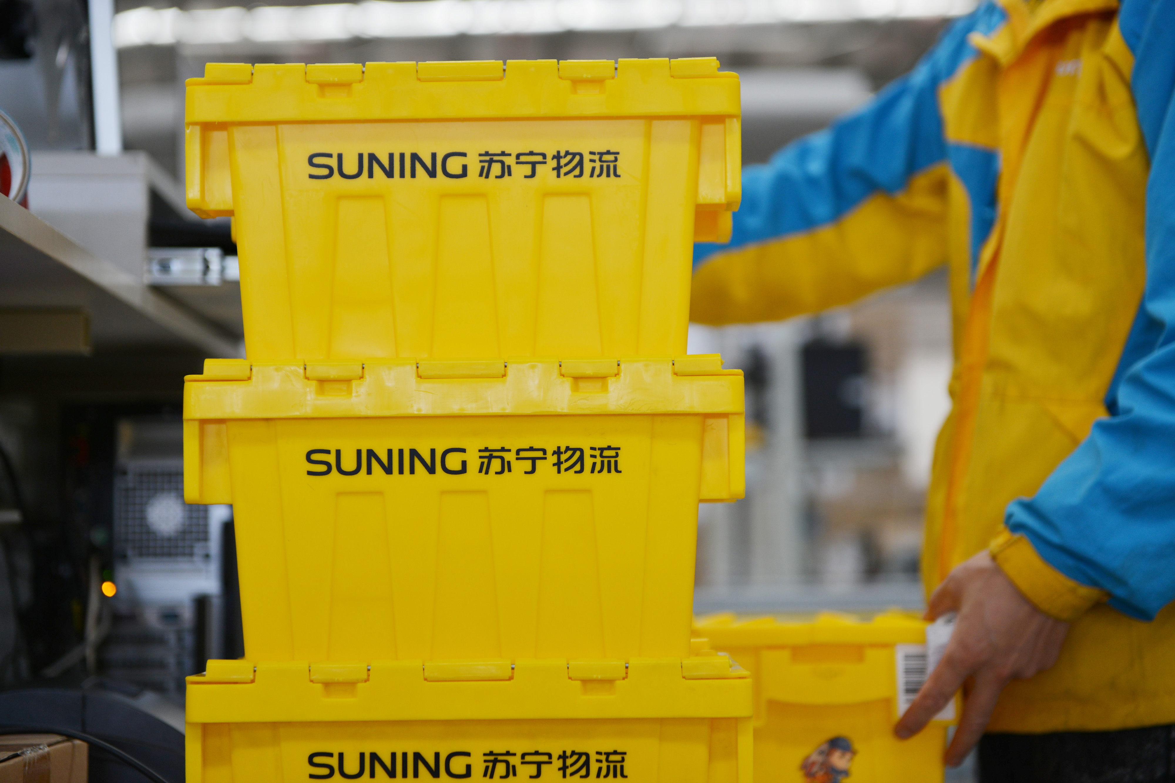 An employee of Suning piles up reusable boxes to be delivered at a logistics center ahead of the Singles Day online shopping festival in Nanjing