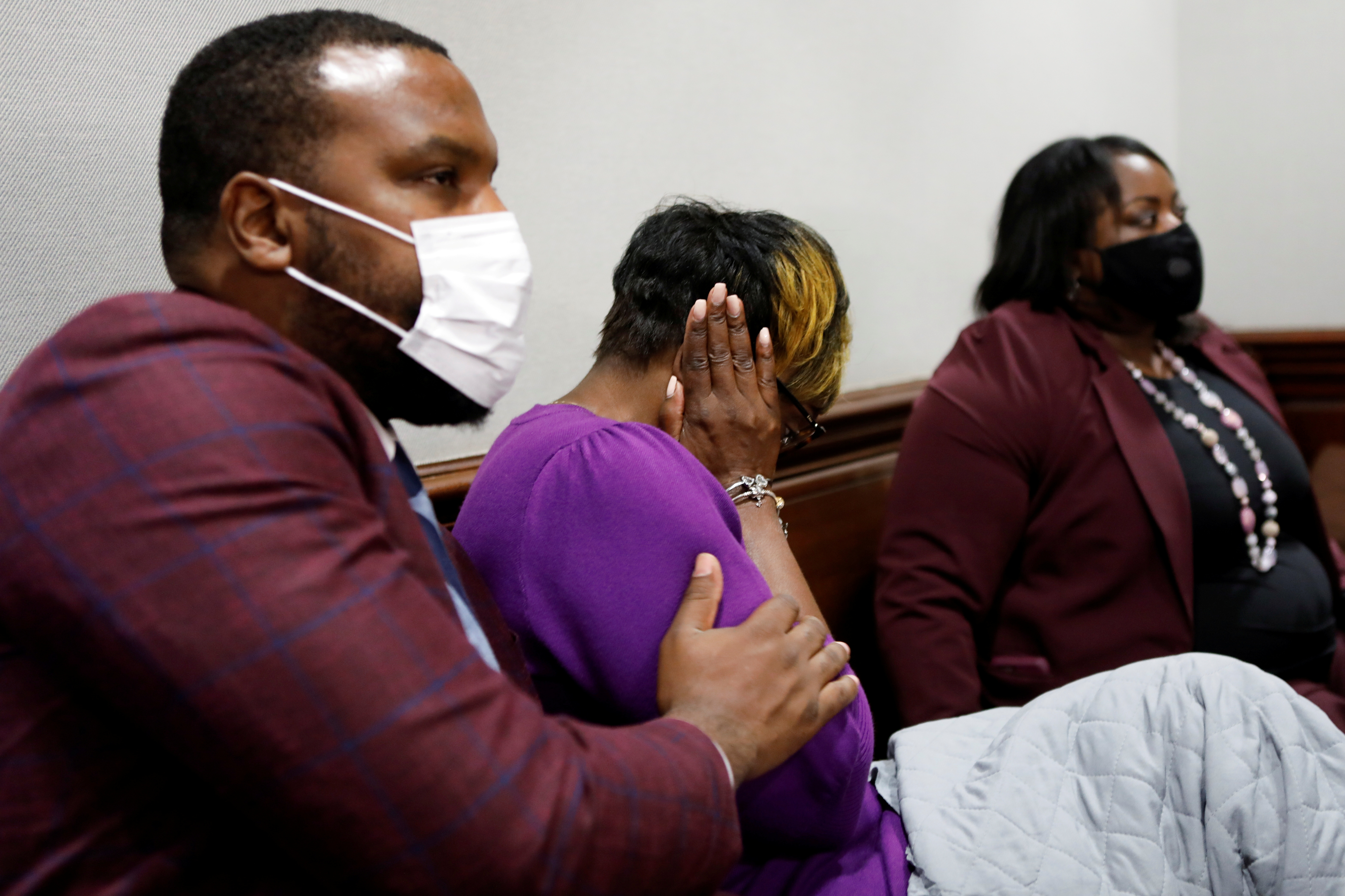 Attorney Lee Merritt consoles Wanda Cooper-Jones, mother of Ahmaud Arbery, as she reacts while seeing photos of her son on a monitor, during the trial of William 