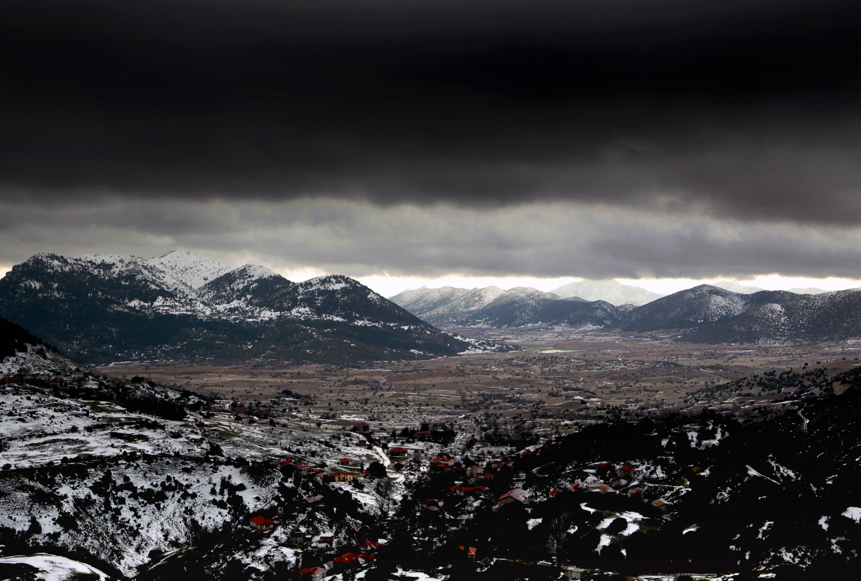 A storm approaches the snow covered mountain range of Panachaiko