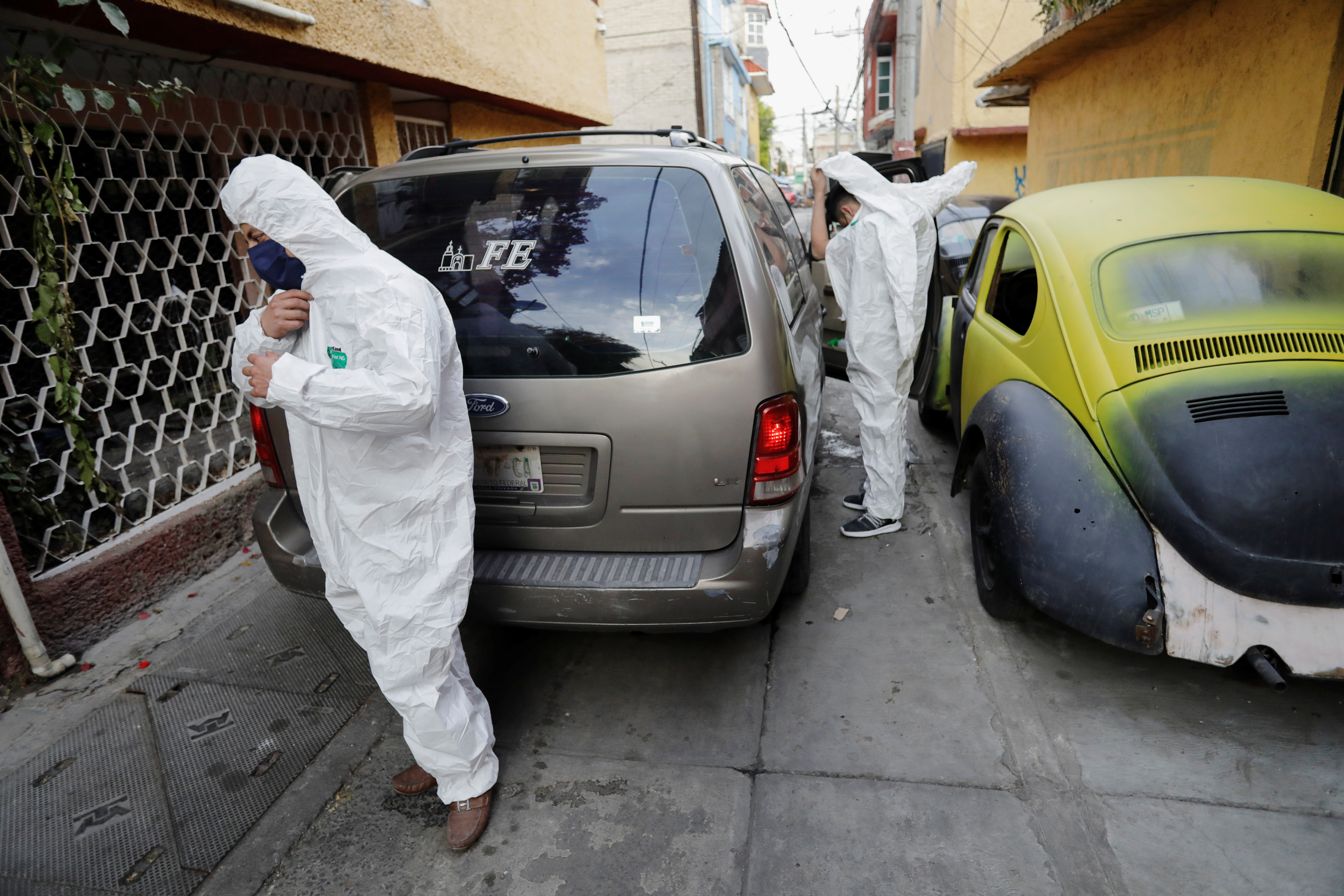 Employees of a funeral parlor get ready to remove the body of a person who died from the coronavirus disease (COVID-19) from a house, amid the COVID-19 outbreak, at the Iztapalapa neighbourhood in Mexico City, Mexico January 19, 2021. Picture taken January 19, 2021. REUTERS/Gustavo Graf
