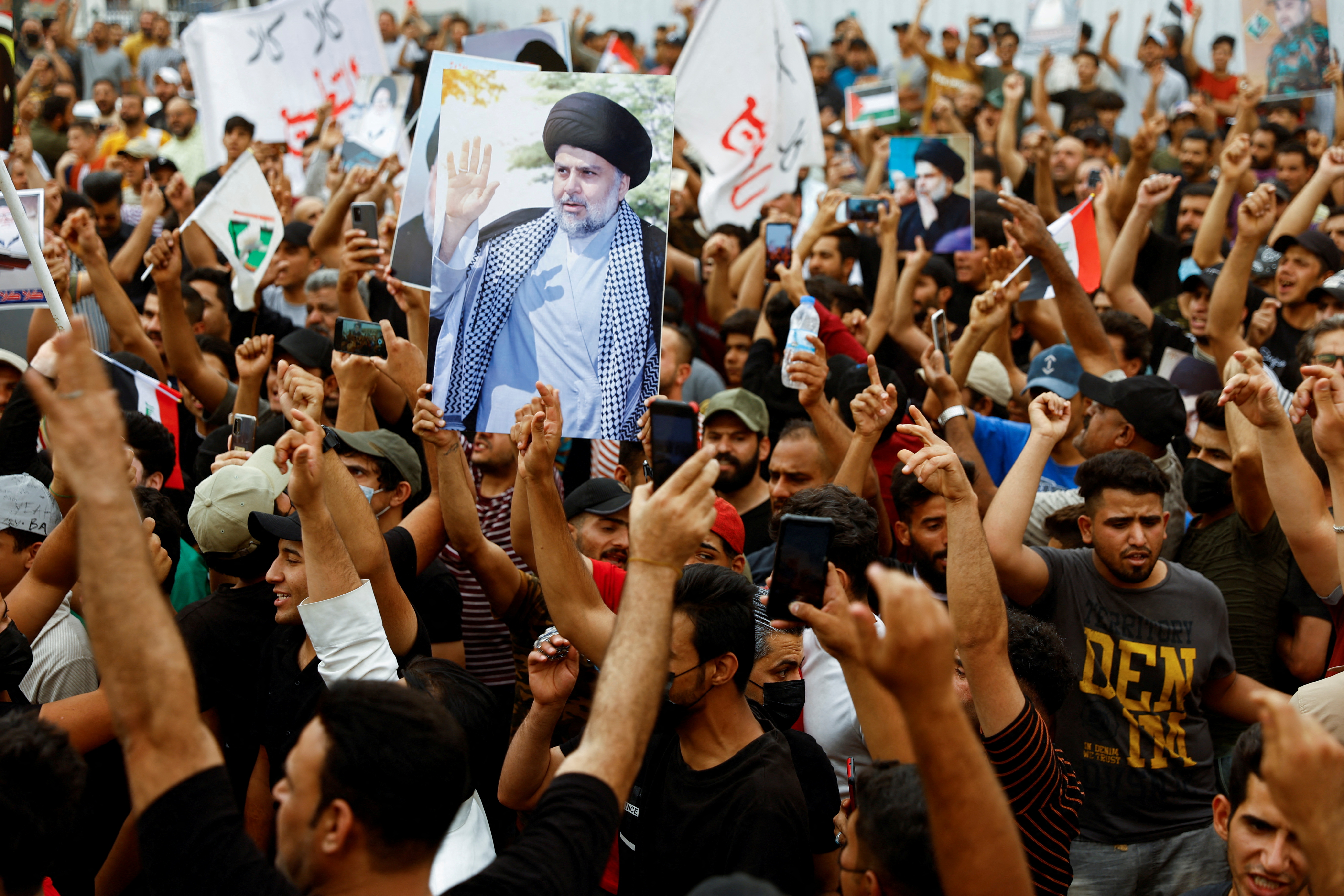 Supporters of Iraqi Shi'ite Muslim cleric Muqtada al-Sadr shout slogans during a celebration after Iraq's parliament passed a law criminalising normalisation of relations with Israel, in Baghdad