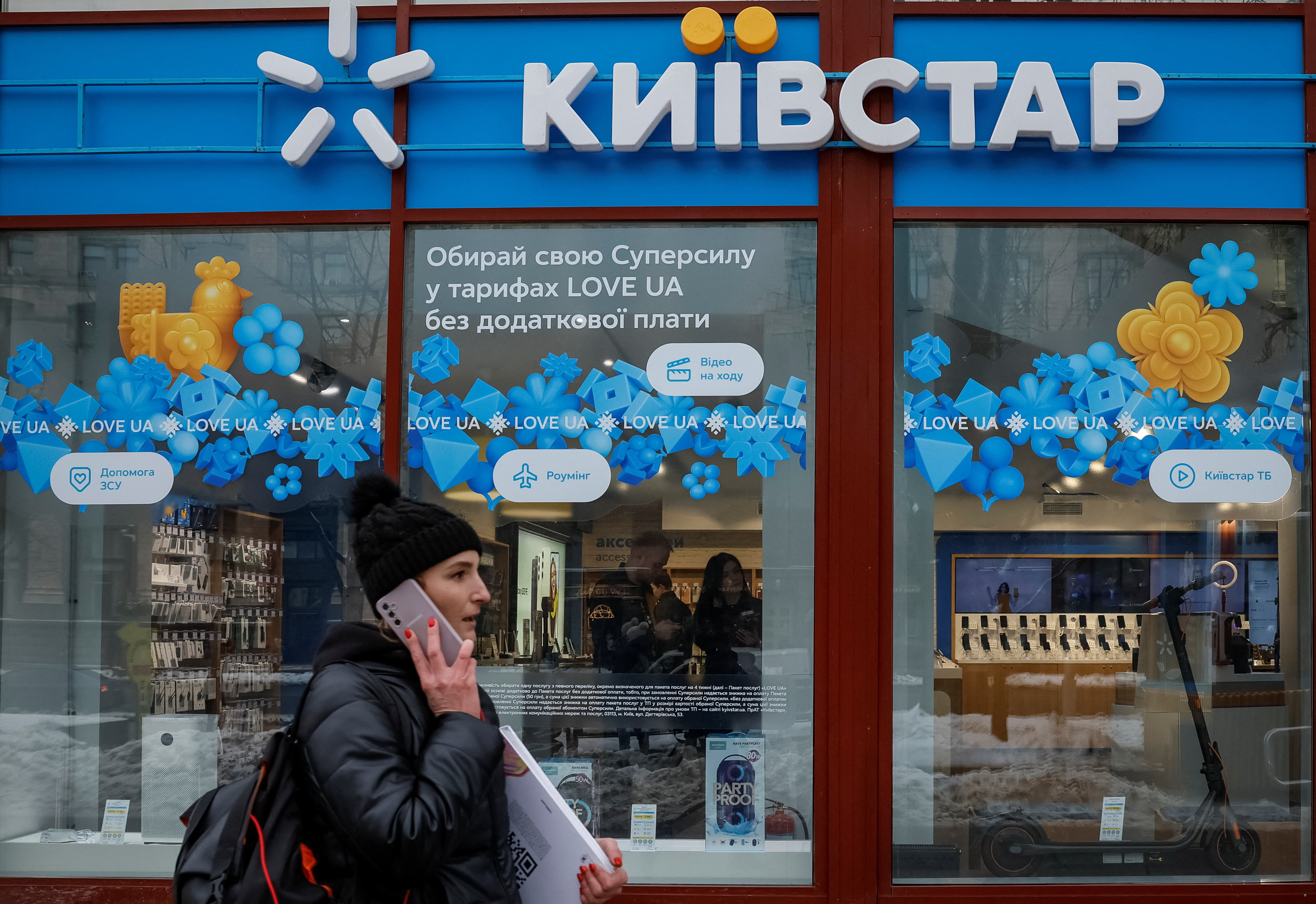 Woman walks past a Kyivstar store in Kyiv