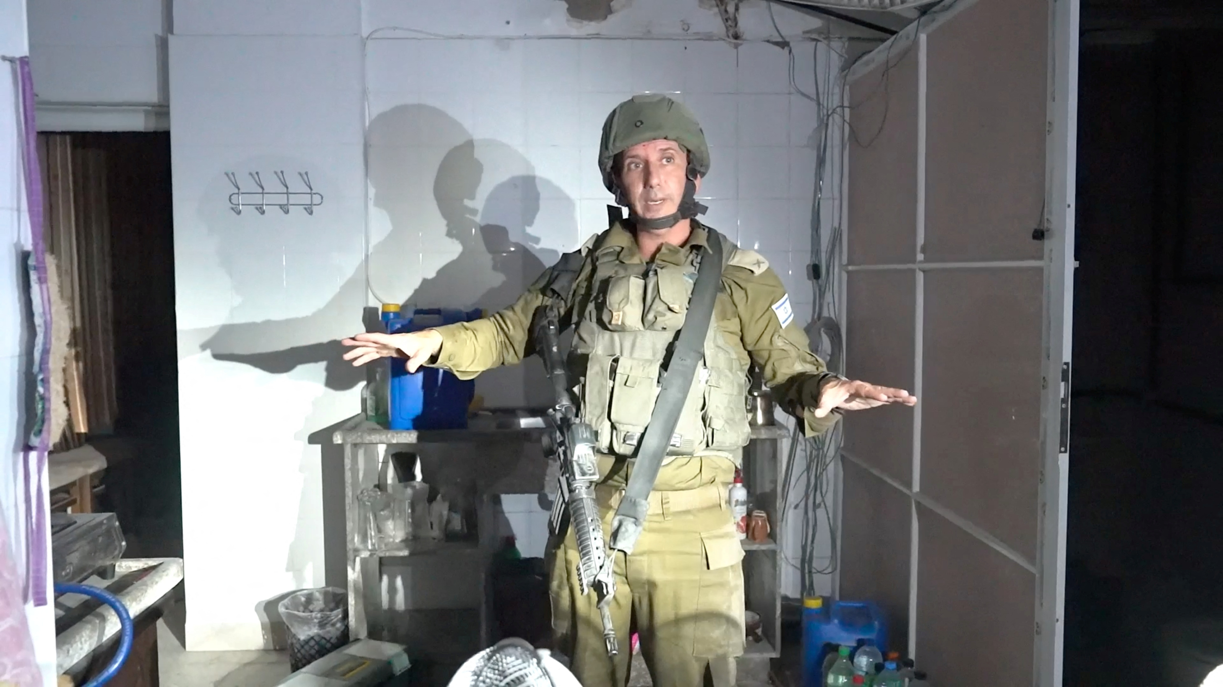 Israeli military spokesperson Rear Admiral Daniel Hagari gestures as he stands in what he describes as living quarters used by Hamas militants in the basement of Rantissi Hospital