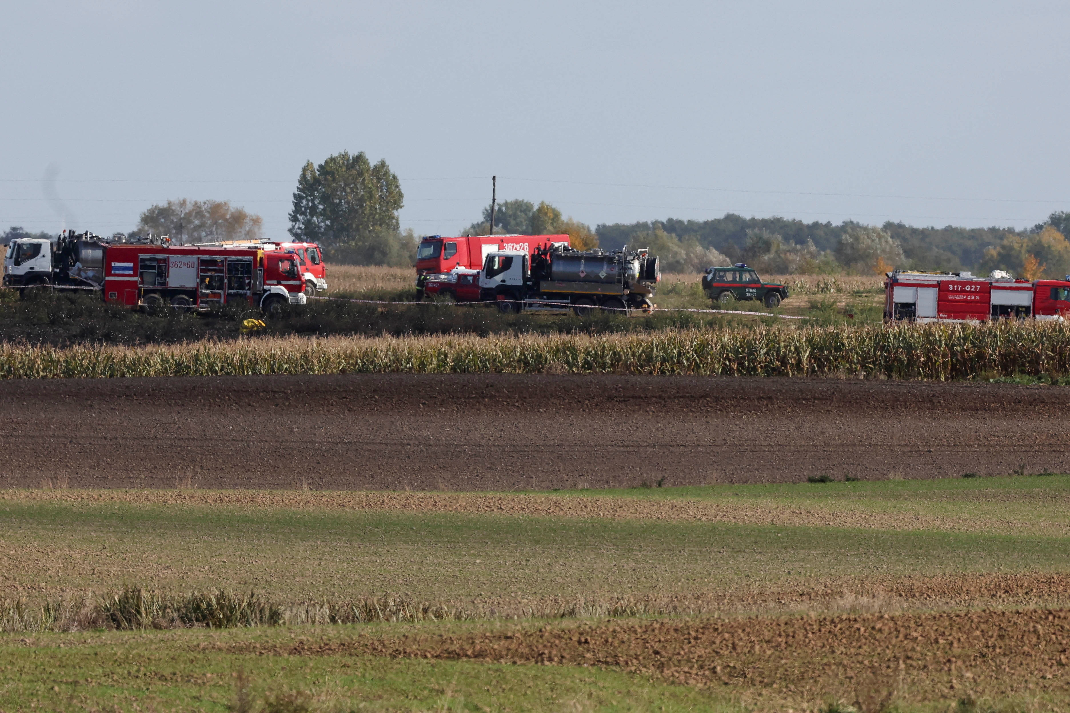 Firefighters work in the field near the Druzhba pipeline where an oil leak was detected