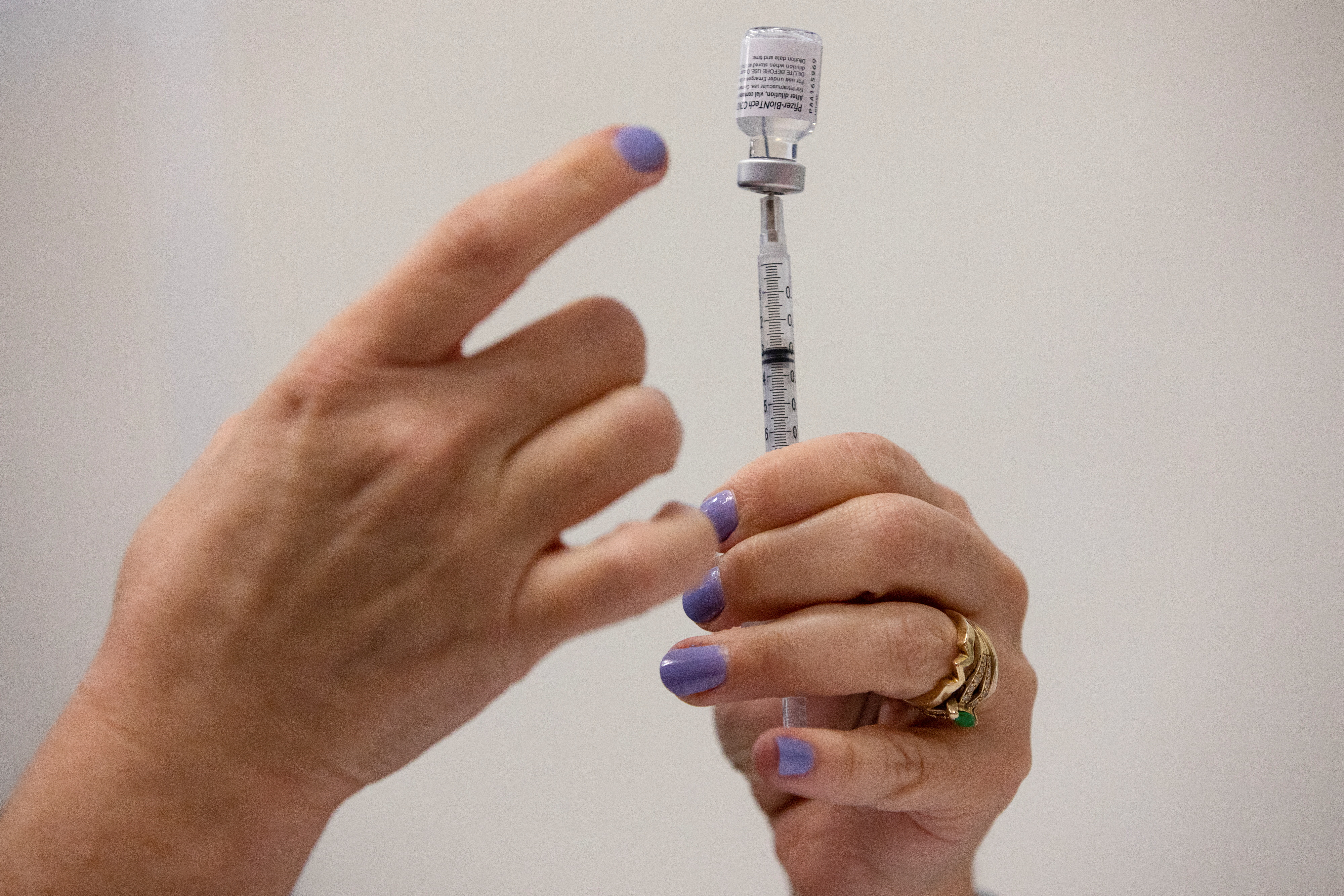 A nurses fills up syringes for patients as they receive their coronavirus disease (COVID-19) booster vaccination during a Pfizer-BioNTech vaccination clinic in Southfield, Michigan, U.S., September 29, 2021. REUTERS/Emily Elconin