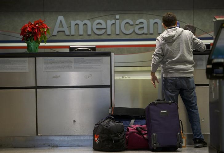 A man checks in his luggage at the American Airlines check-in counter at Philadelphia International Airport