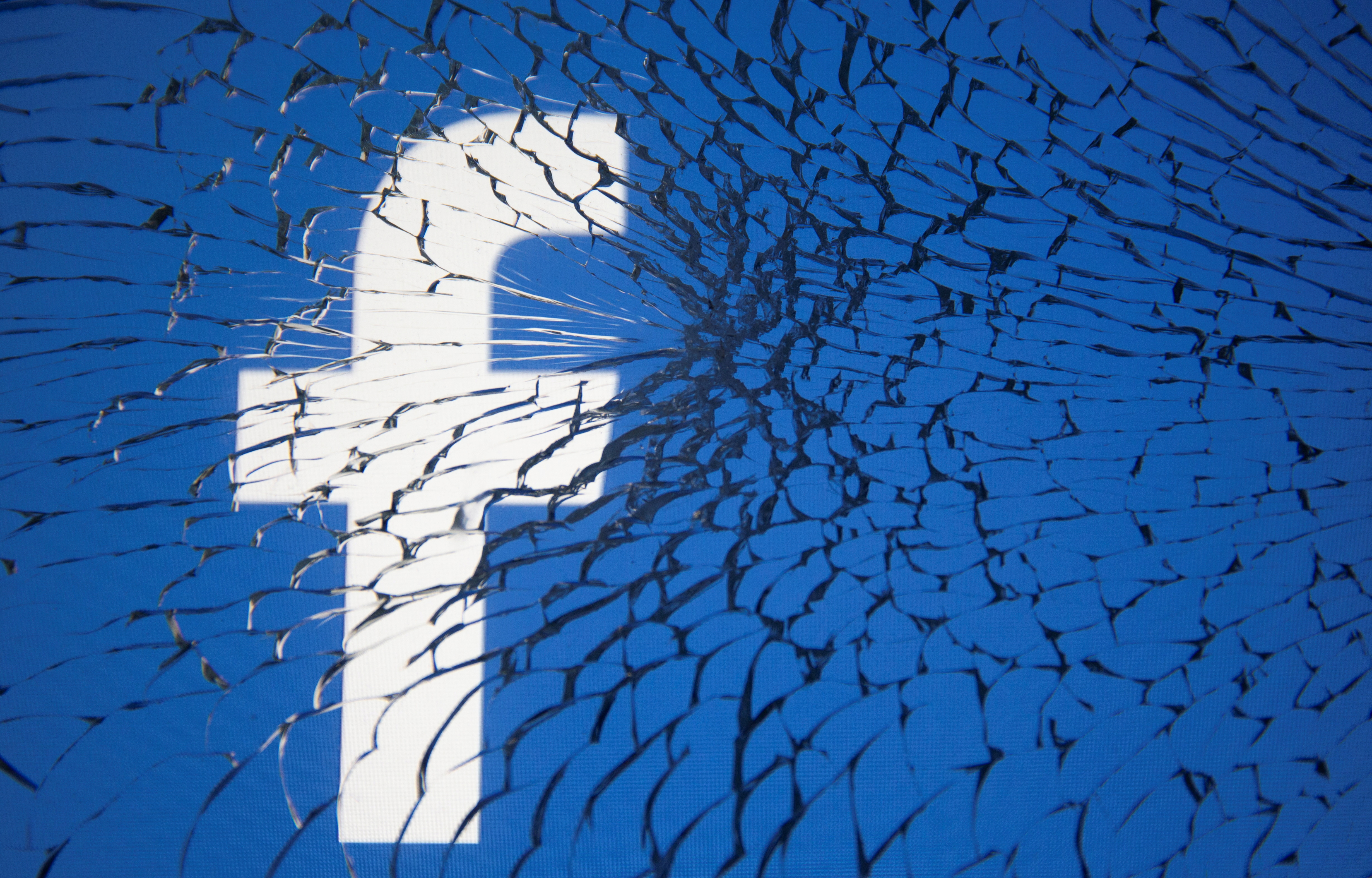 Facebook logo is displayed through broken glass in this illustration taken October 4, 2021. REUTERS/Dado Ruvic/Illustration/File Photo