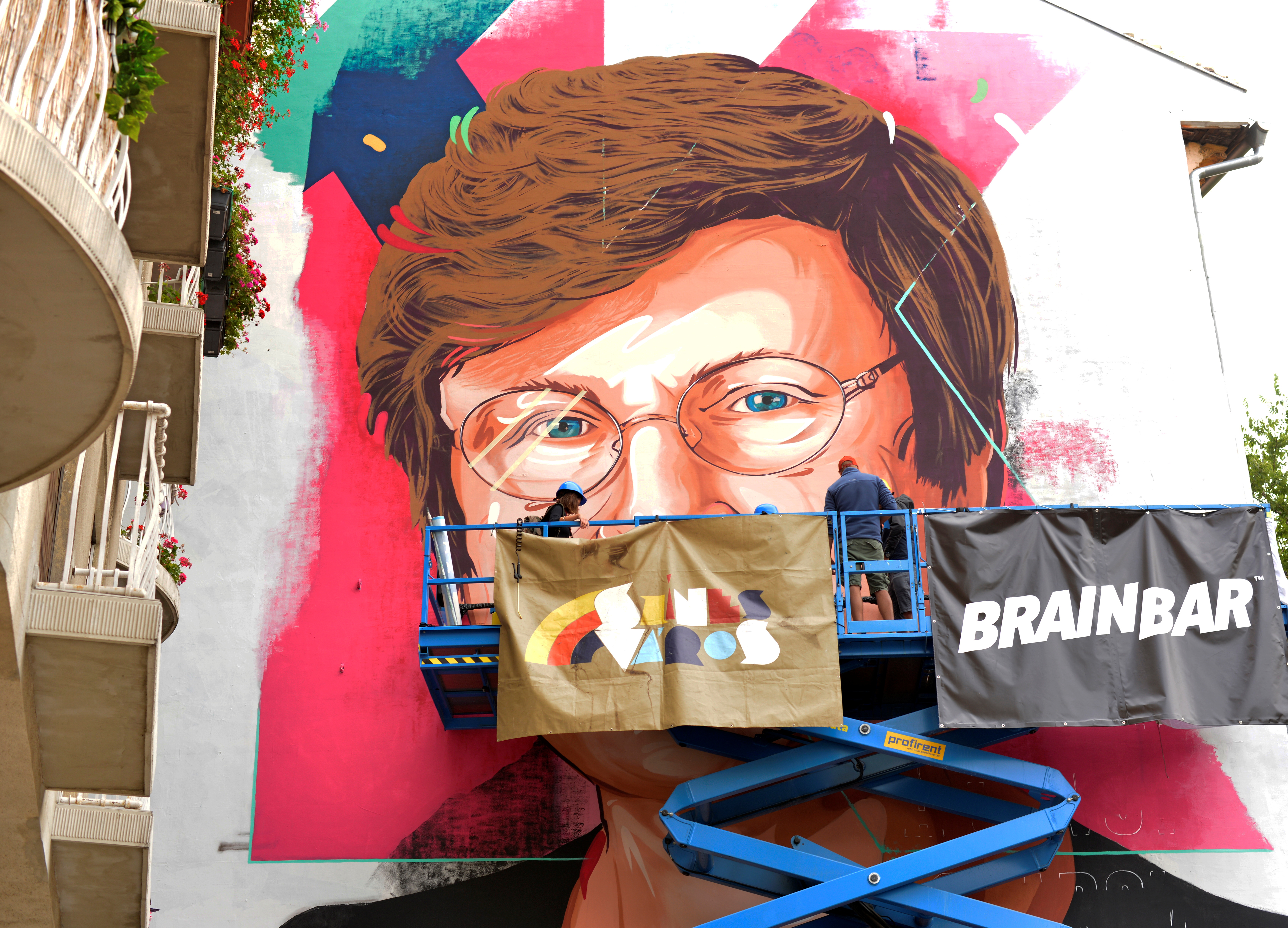 A painter makes finishing touches on a mural showing a portrait of Katalin Kariko, a Hungarian-born scientist and senior vice president at BioNTech in Budapest
