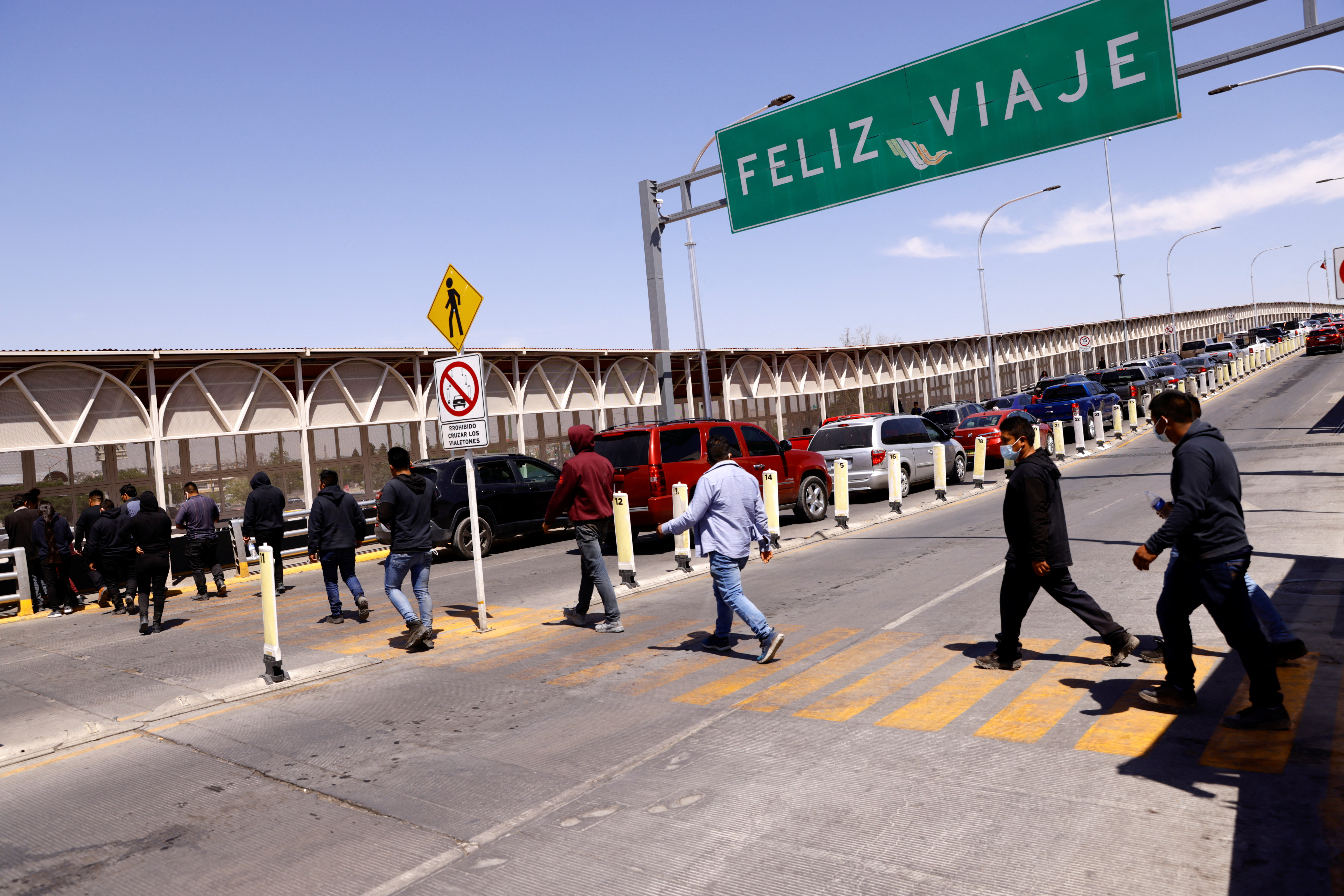 Migrants expelled from U.S. and sent back to Mexico walk across border bridge in Ciudad Juarez