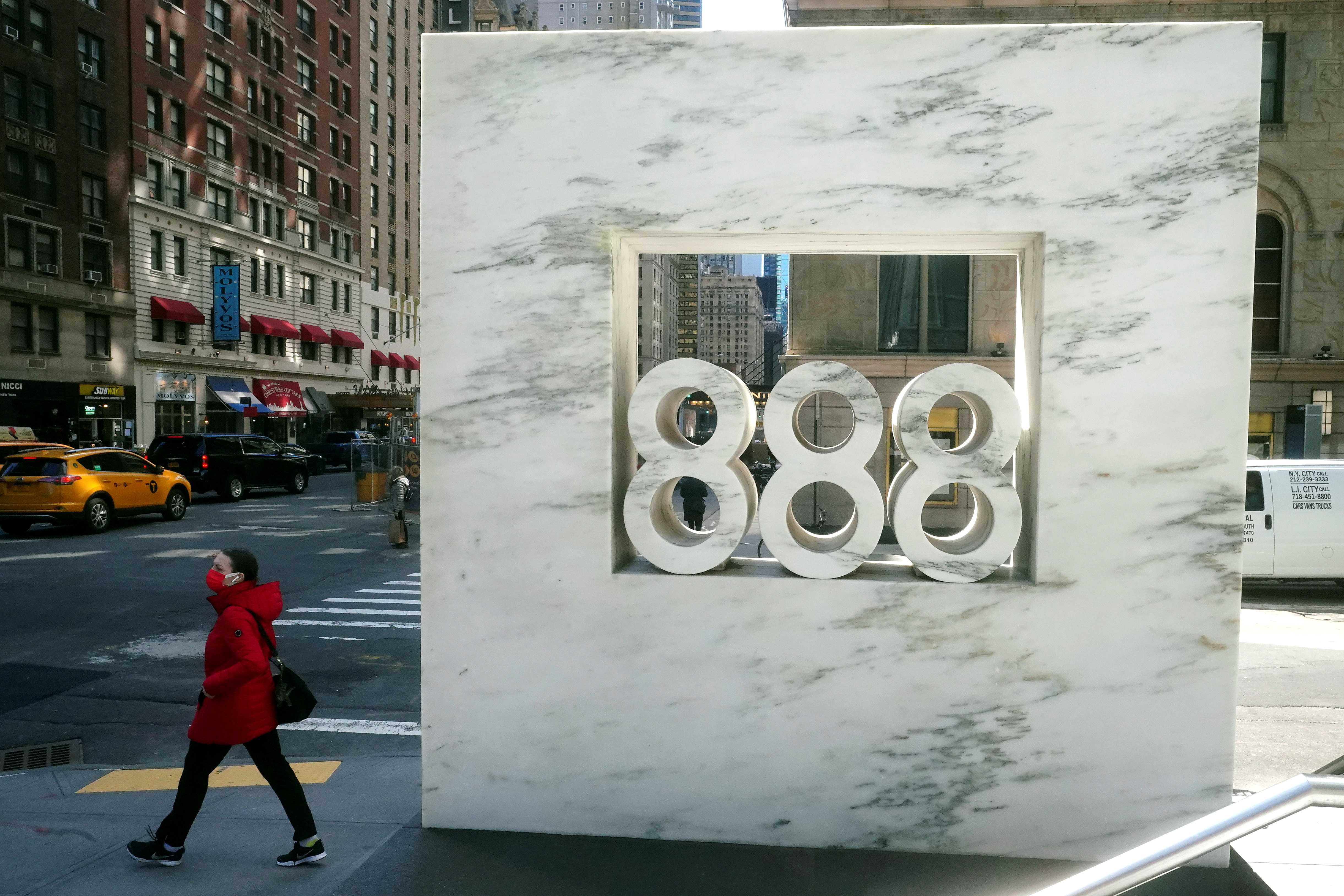 A person walks past 888 7th Ave, a building that reportedly houses Archegos Capital in New York City