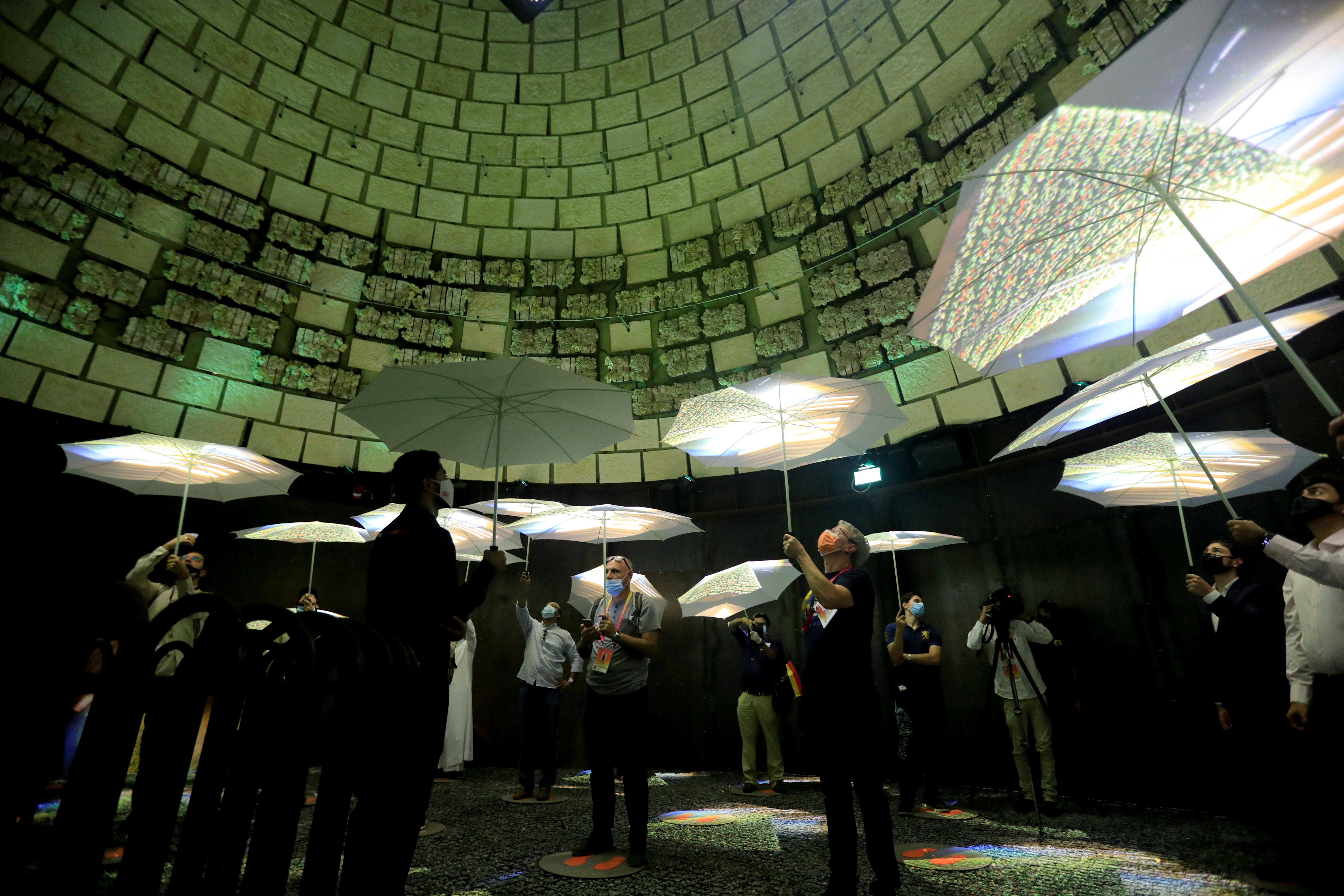 People hold umbrellas as they visit the Netherlands Pavilion at Dubai Expo 2020 in Dubai