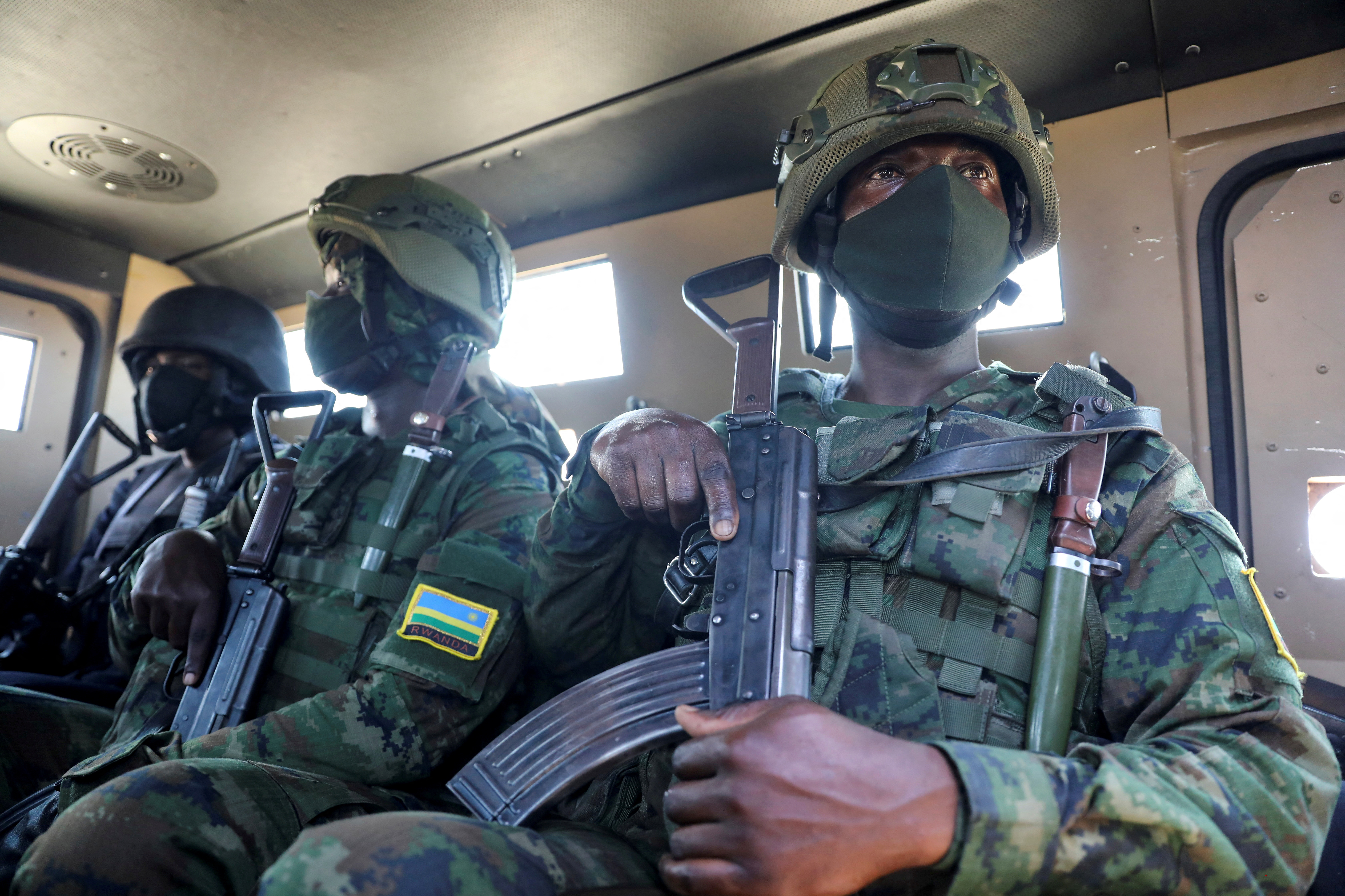 Soldiers from the Rwandan security forces sit inside an APC near the Afungi natural gas site