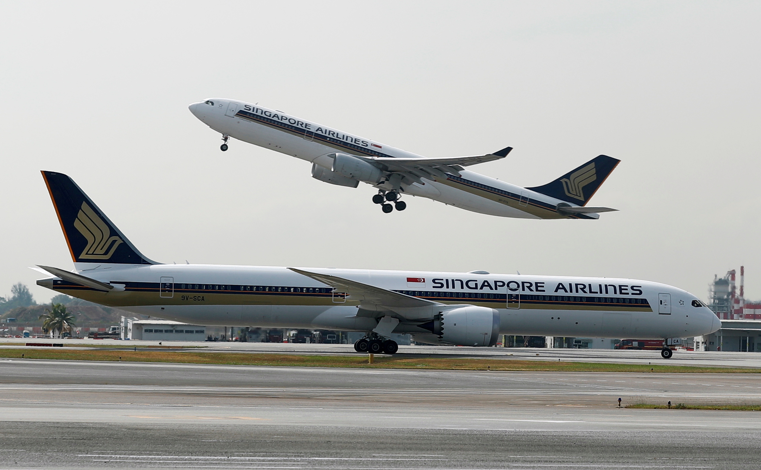 A Singapore Airlines Airbus A330 plane takes off behind a Boeing 787 Dreamliner at Changi Airport in Singapore