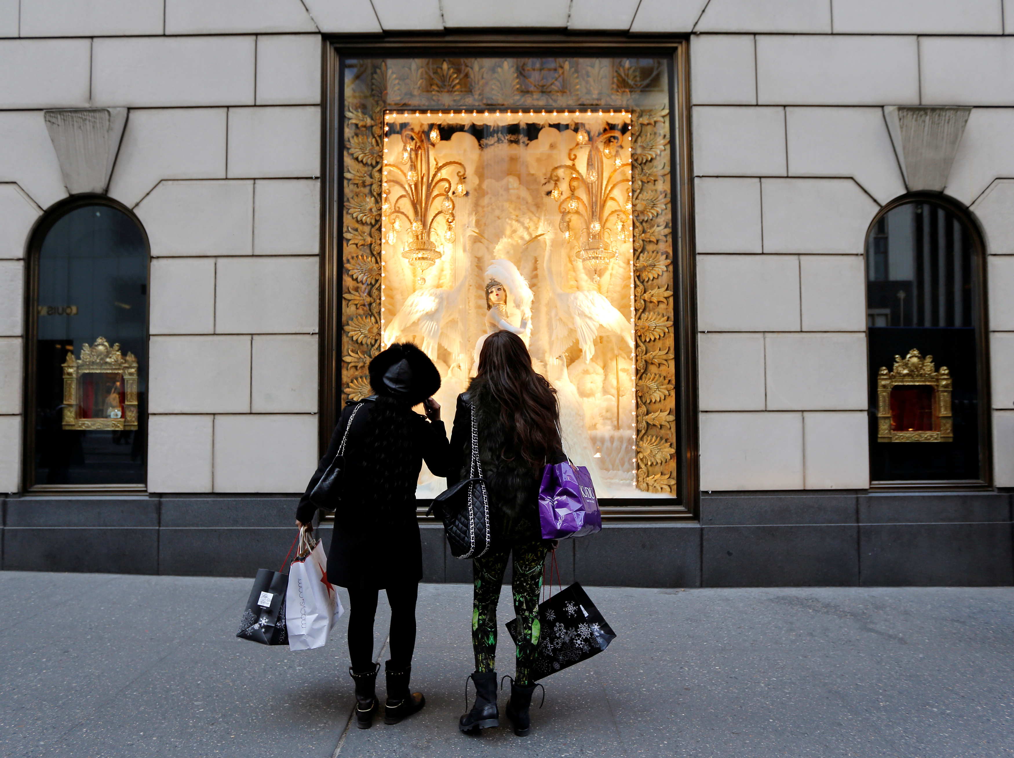Holiday shoppers look at store windows at Henri Bendel store on 5th Avenue in New York