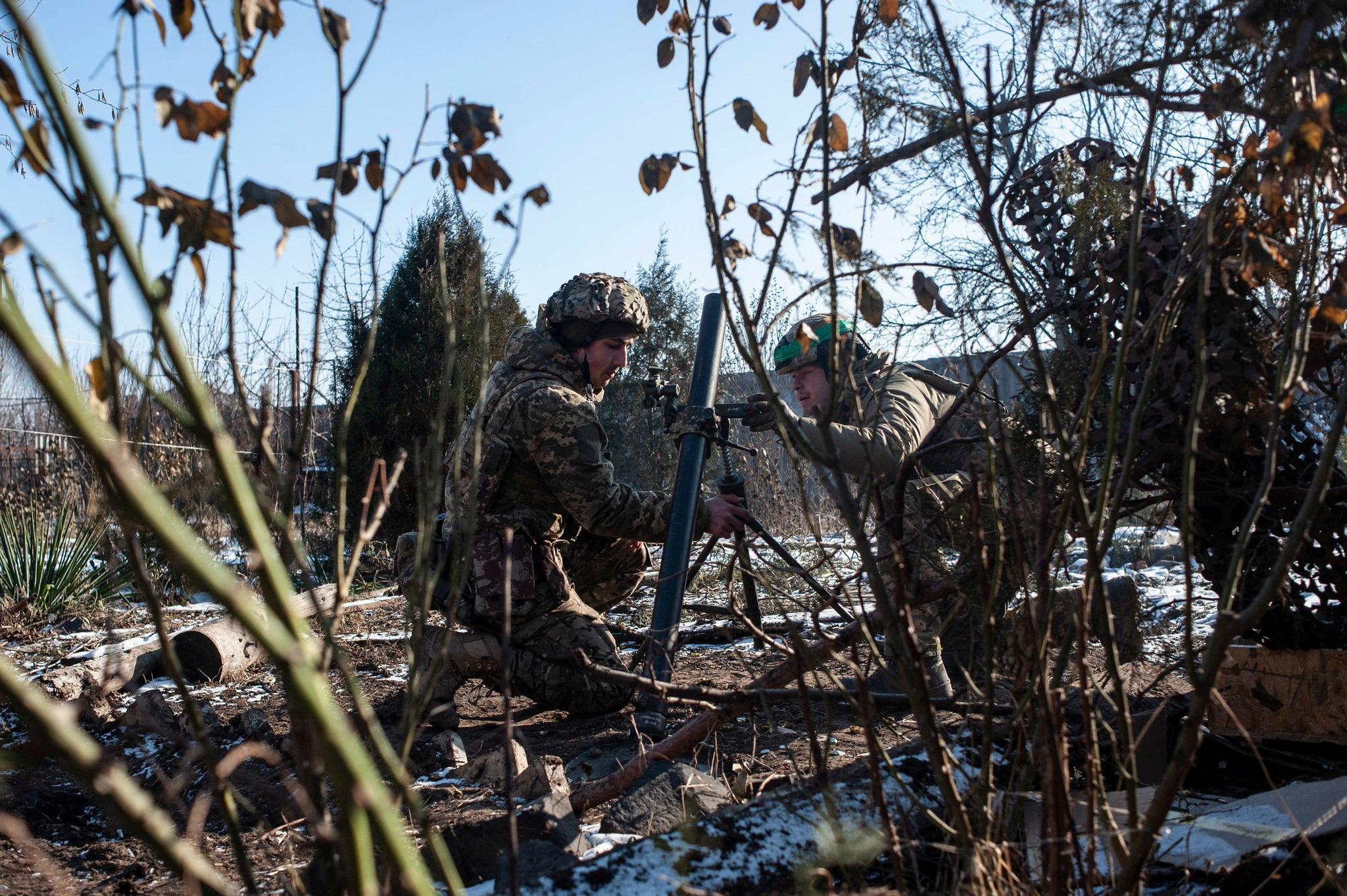 Ukrainian service members prepare a mortar to fire toward Russian troops in the frontline town of Bakhmut