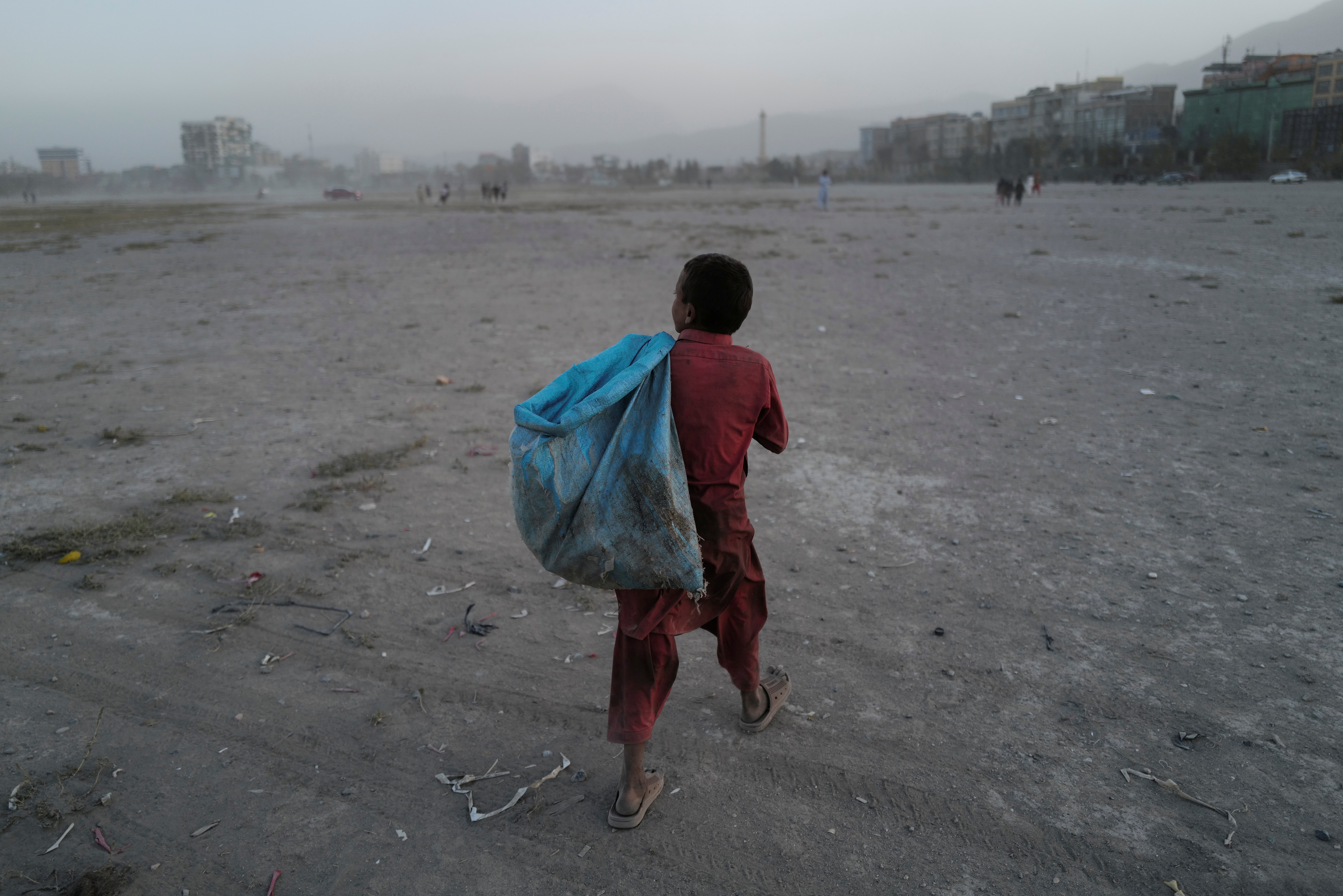 Eftekhar, 14, carries a bag filled with plastic bottles he collected, to be sold, as he walks in a playground in Kabul, Afghanistan, October 22, 2021. REUTERS/Zohra Bensemra