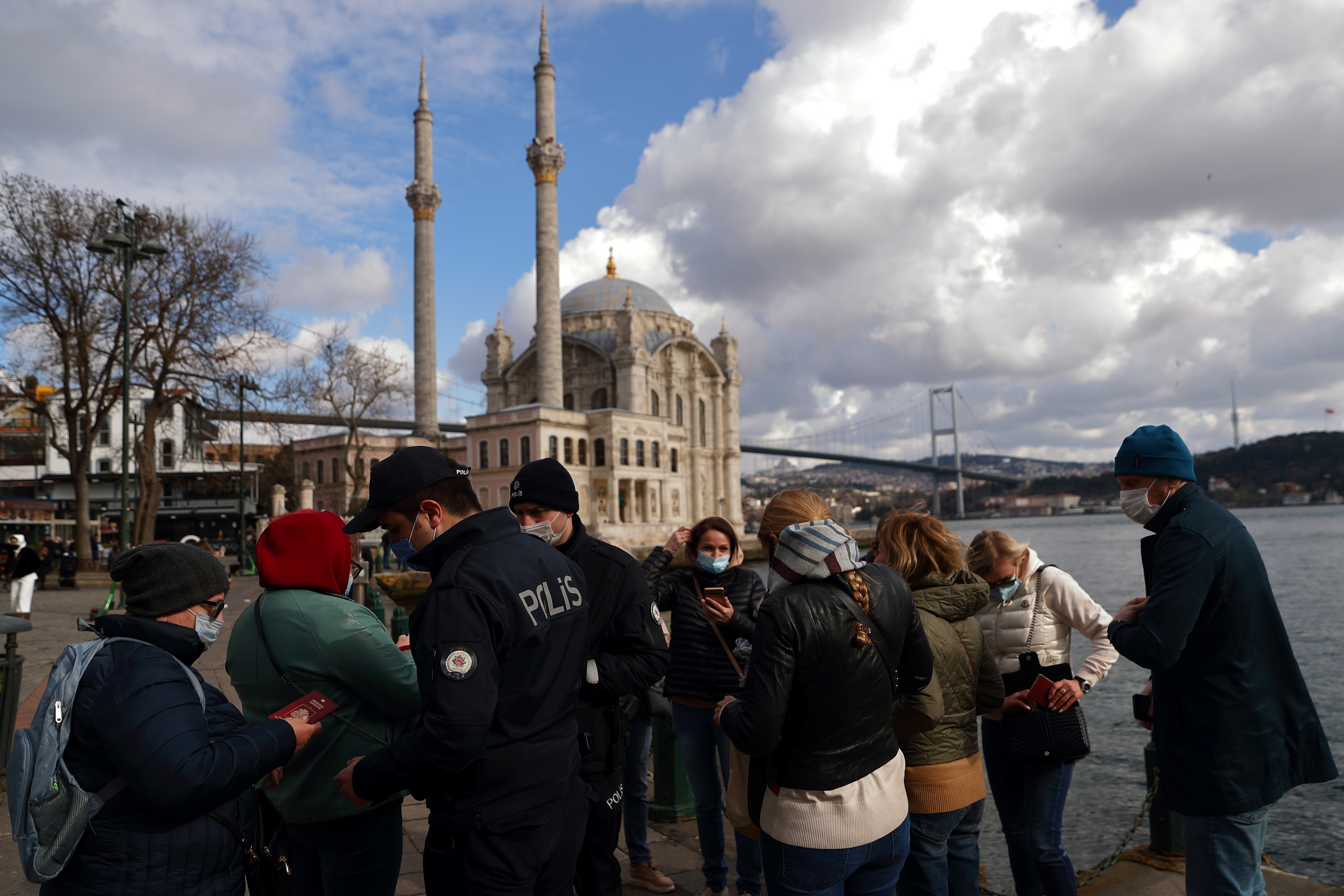 Turkish police officers check passports of a group of Russian tourists at Ortakoy square in Istanbul