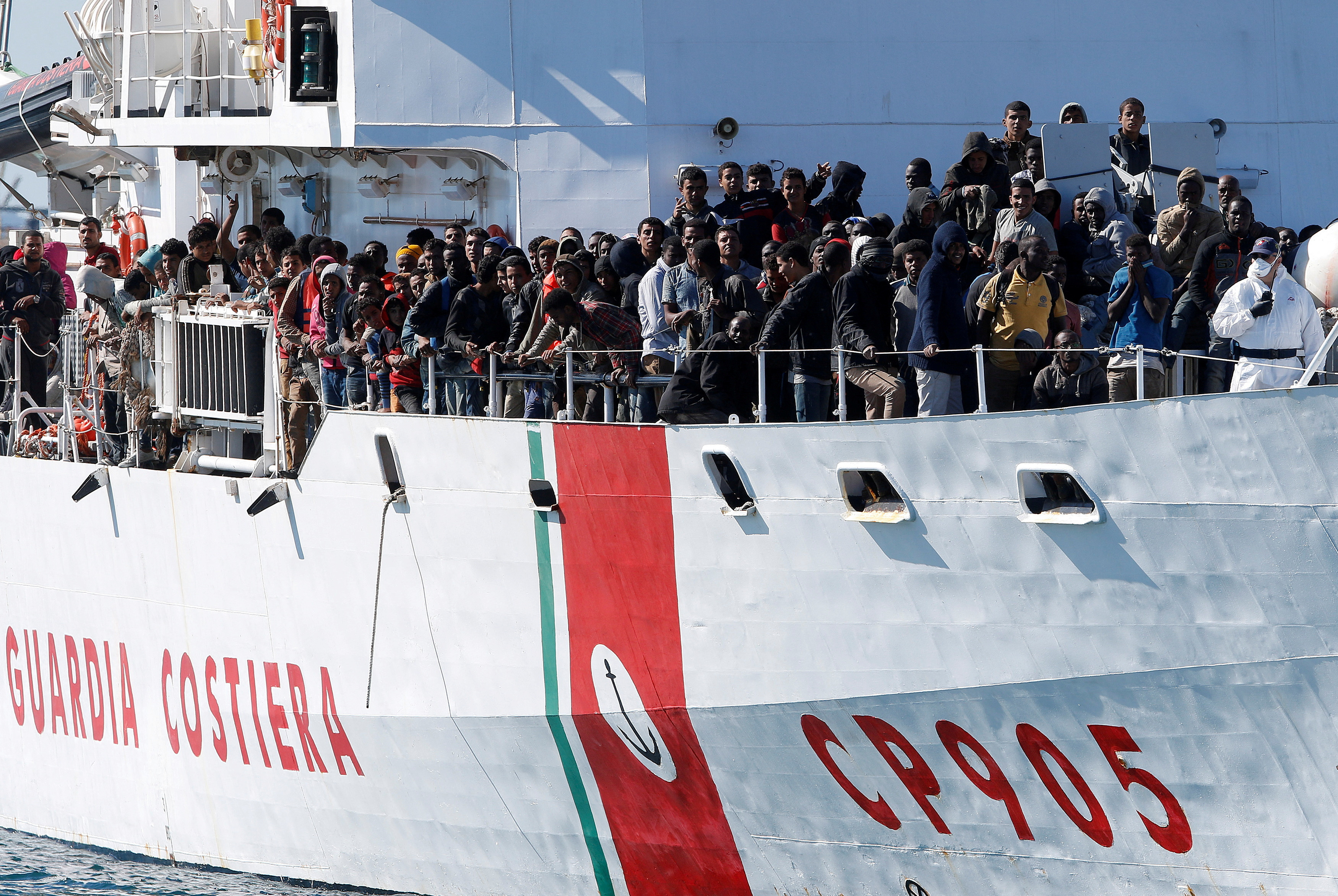 Migrants arrive by the Italian coastguard vessel Peluso in the Sicilian harbour of Augusta