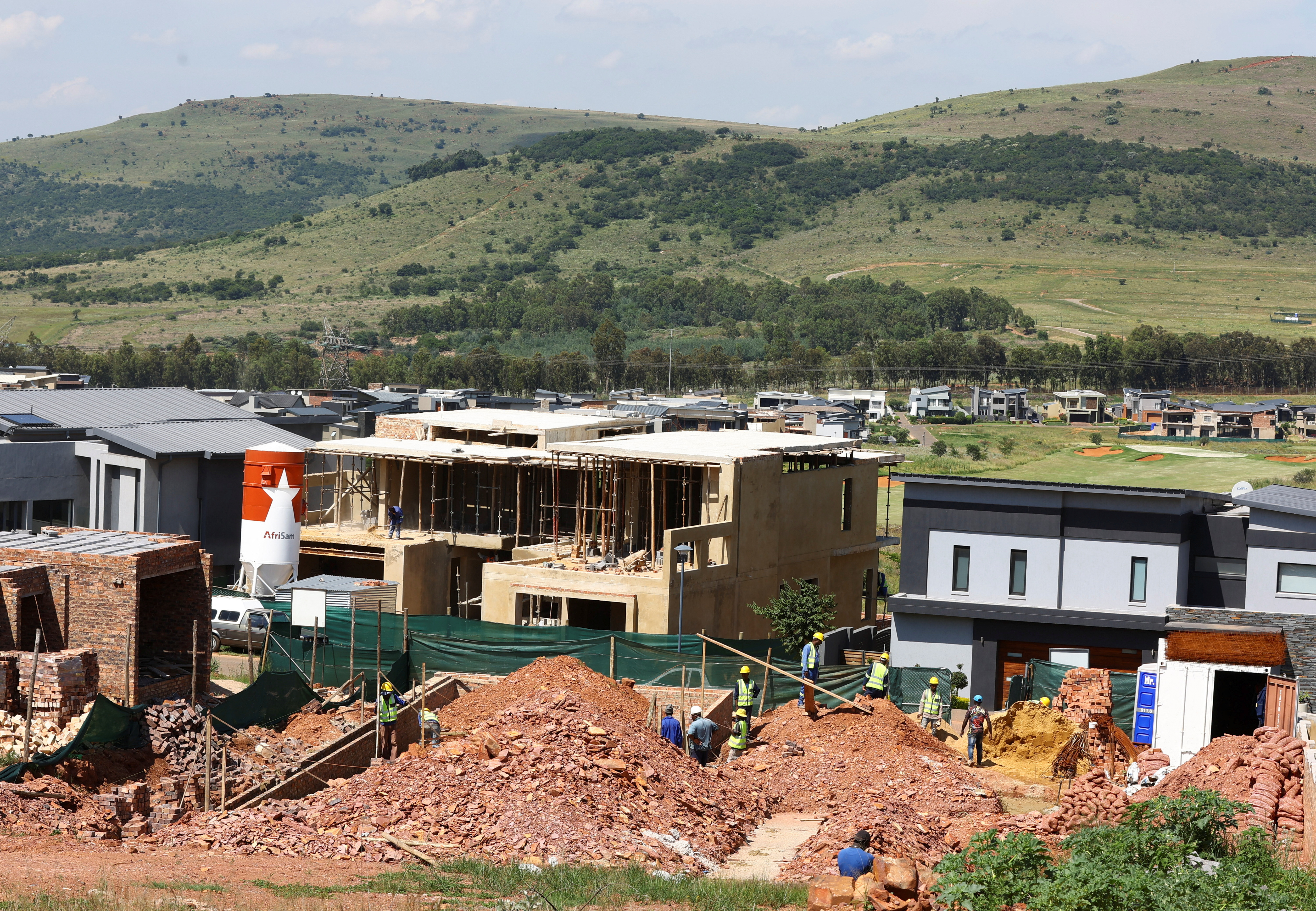 Workers are seen at a construction site of a housing estate