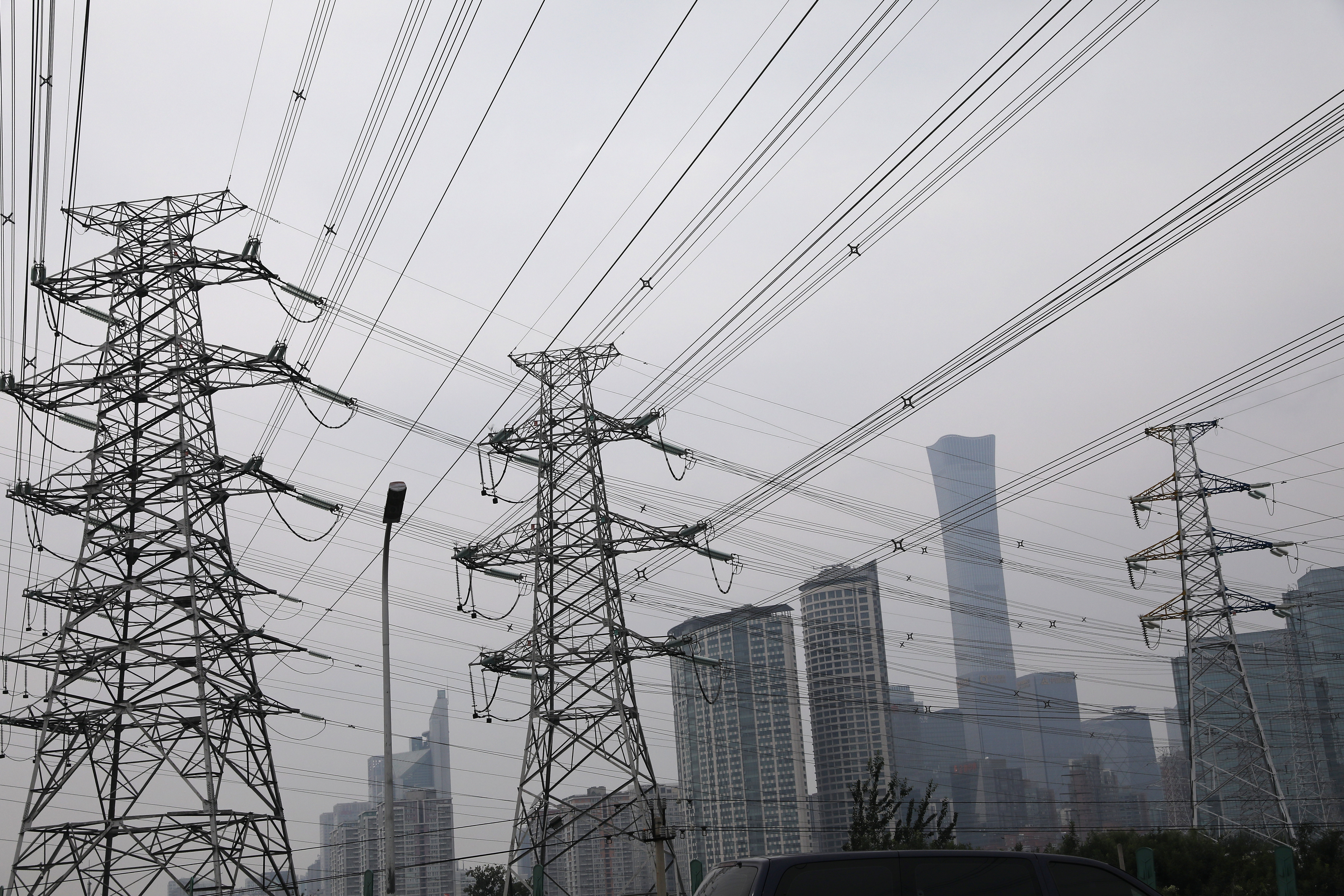 Electricity transmission towers are pictured near Beijing’s Central Business District (CBD), China September 28, 2021. REUTERS/Tingshu Wang