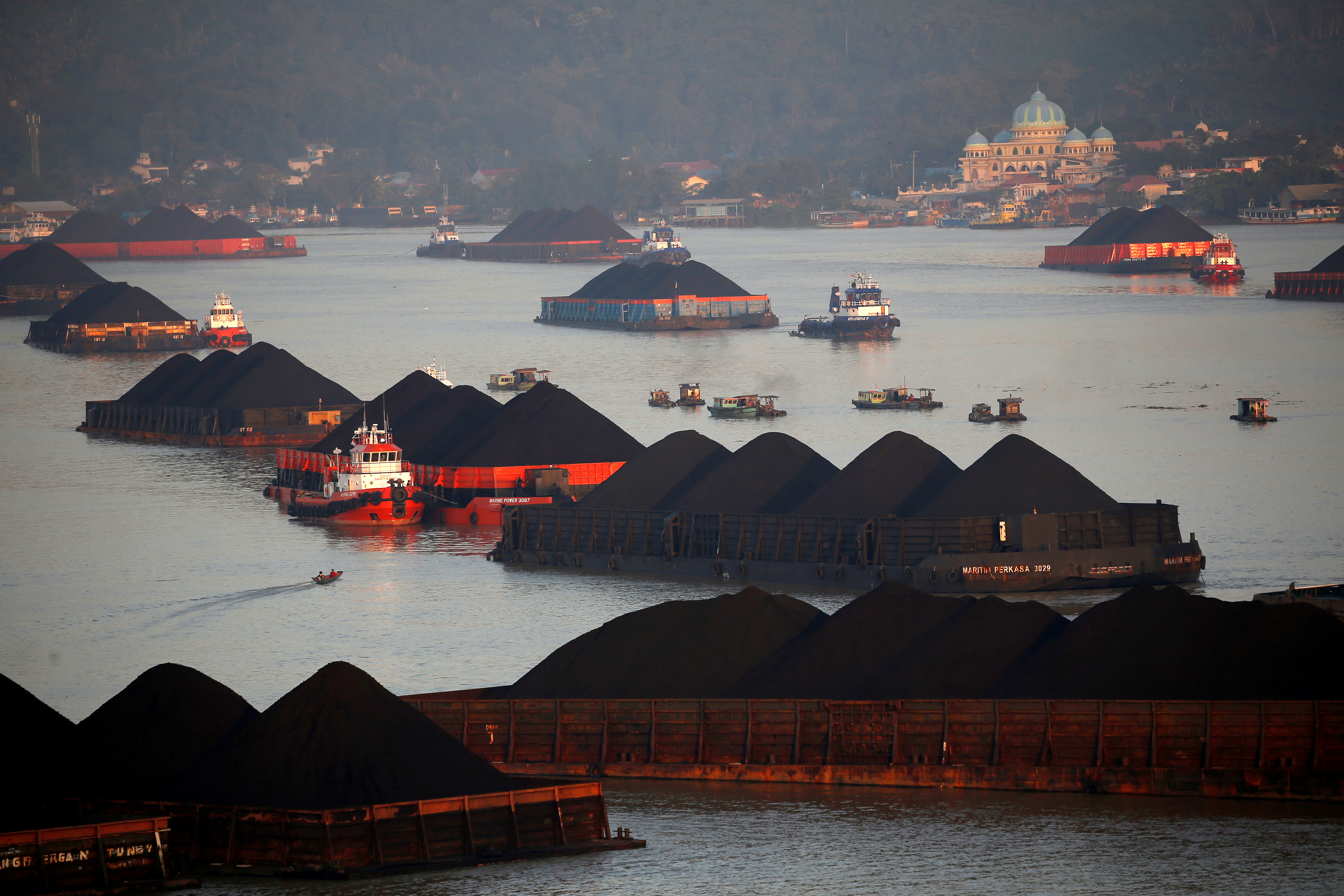 Coal barges are pictured as they queue to be pull along Mahakam river in Samarinda, East Kalimantan province