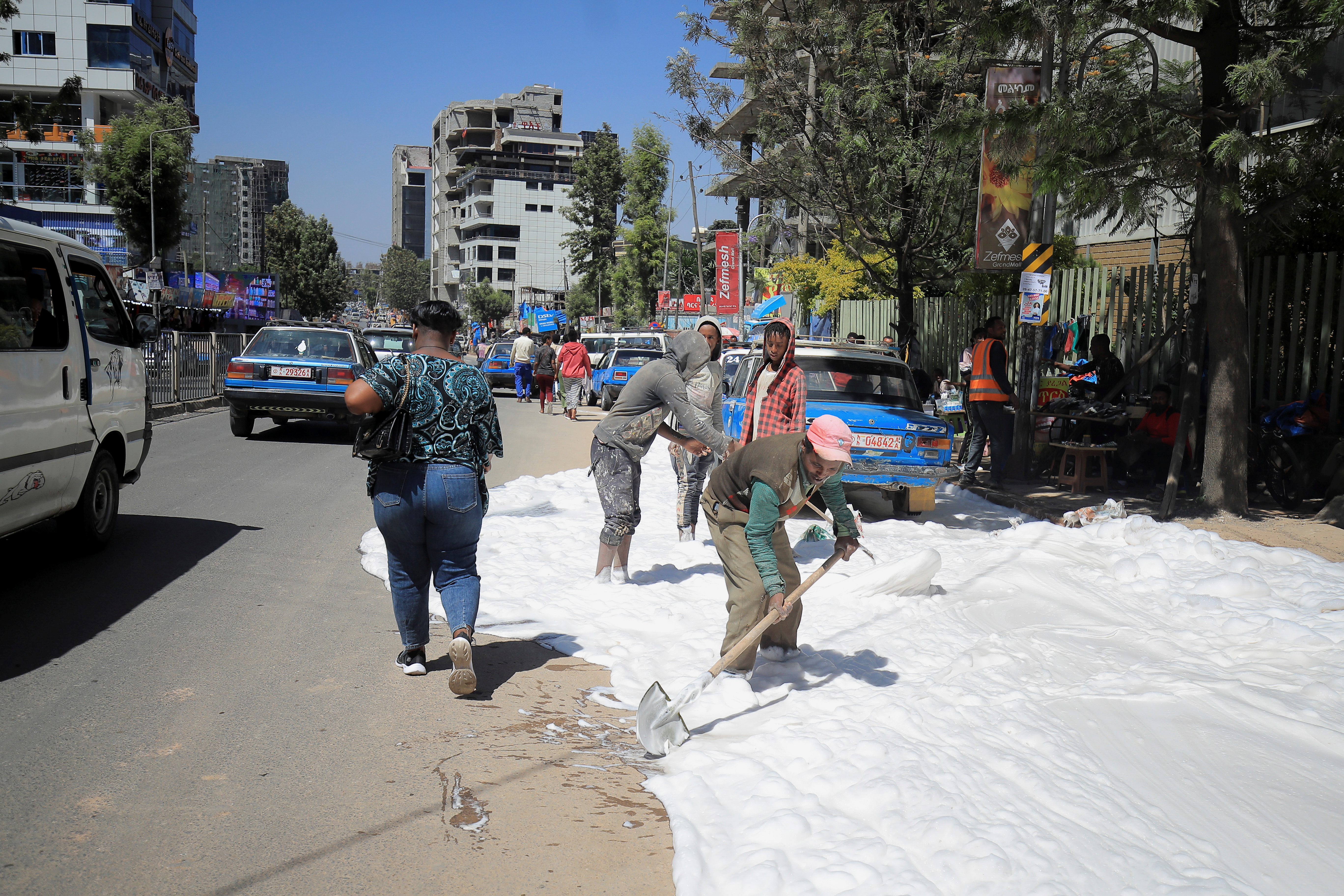 People clean a street in Megenagna neighbourhood in Addis Ababa
