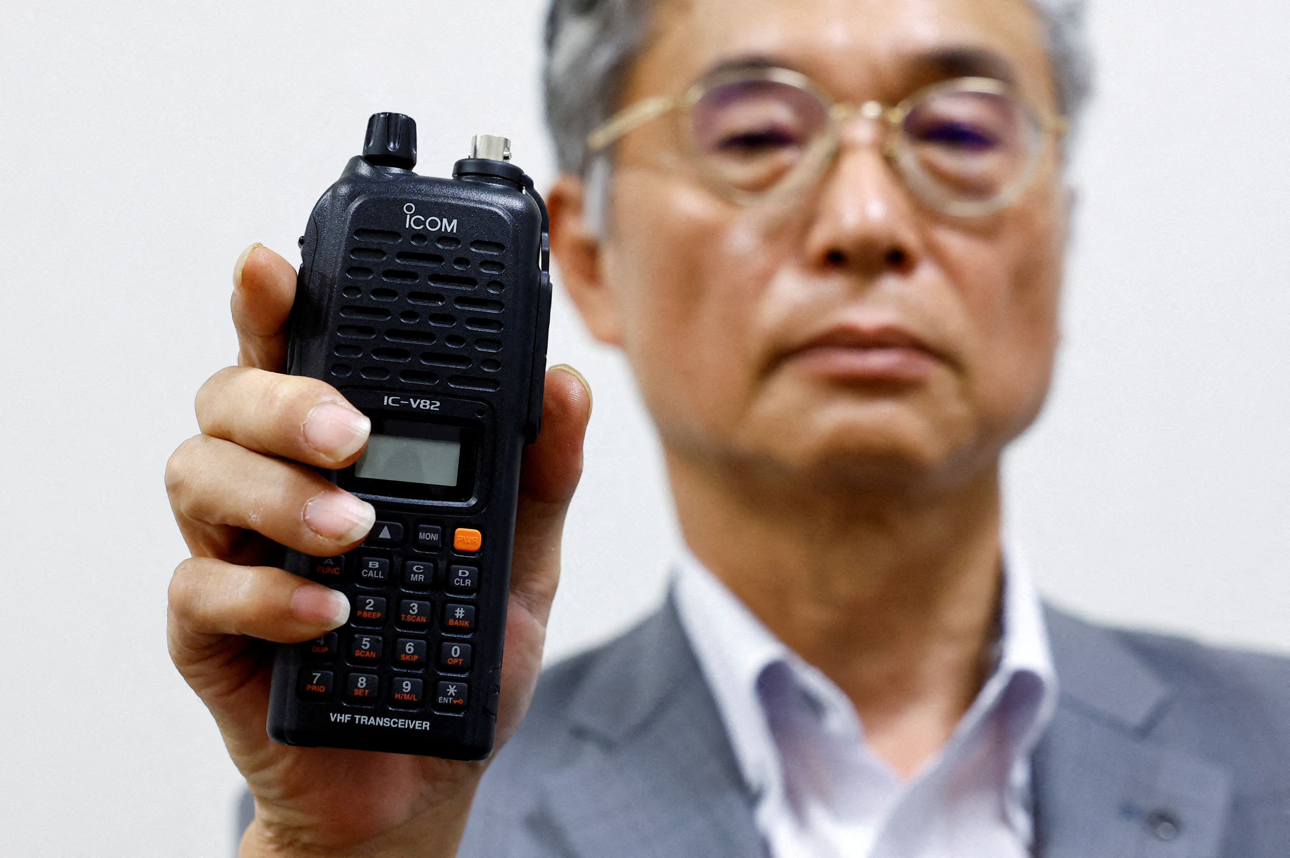 Japanese radio equipment maker Icom Inc director Yoshiki Enomoto shows its model IC-V82 device at its headquarters in Osaka