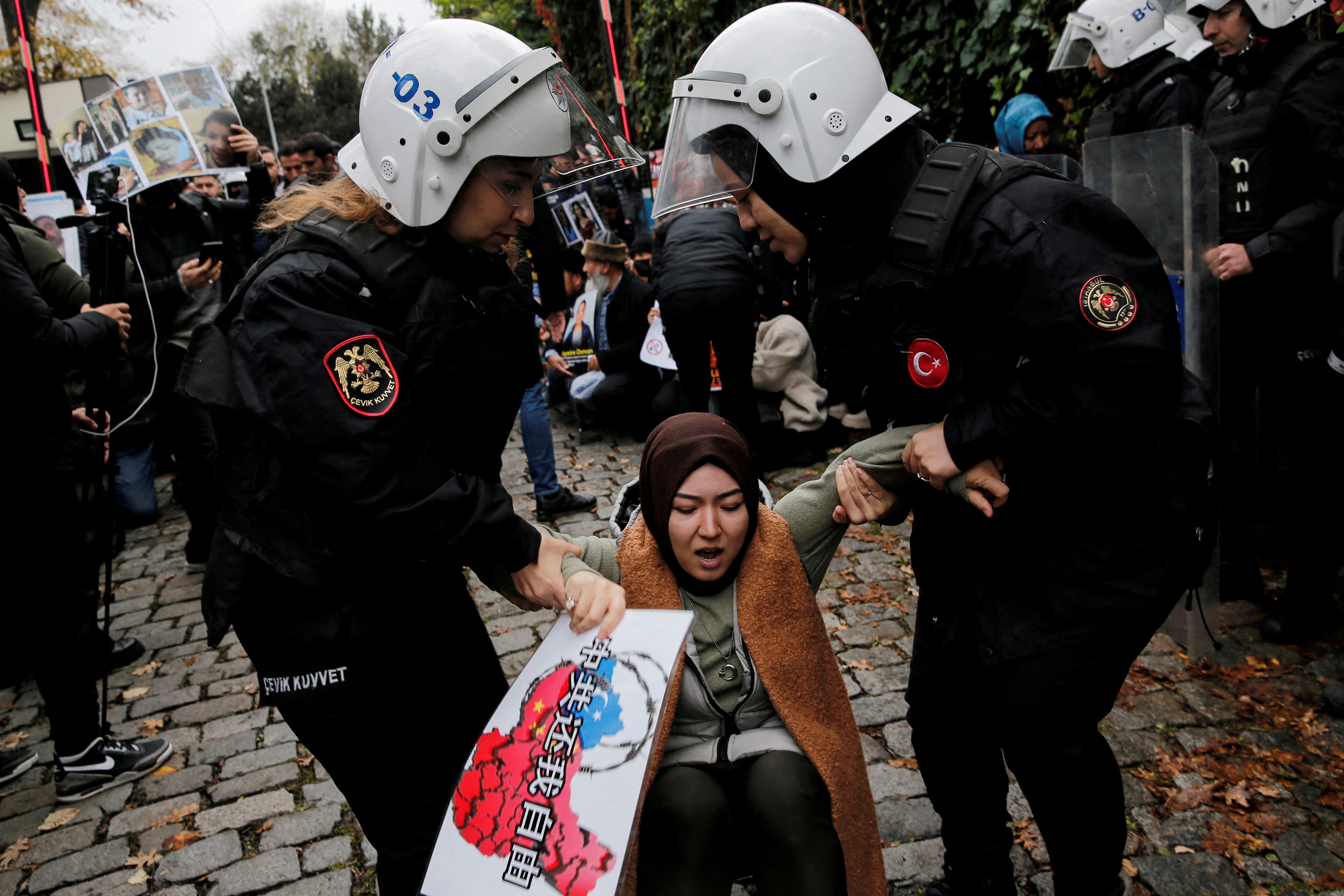 Ethnic Uyghur demonstrators scuffle with riot police as they try to continue a sit-in protest against China