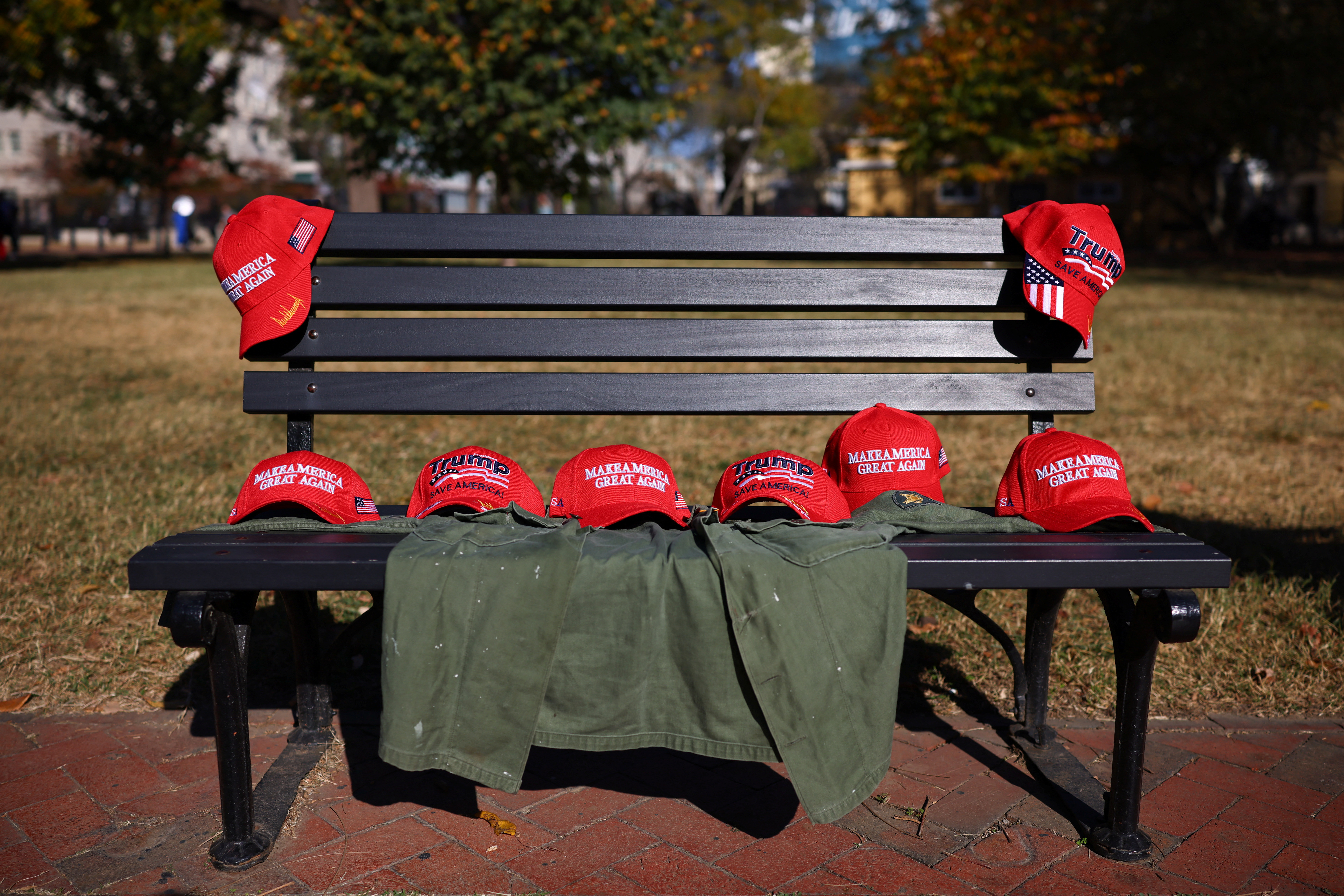 MAGA hats are laid out on a bench outside of the White House