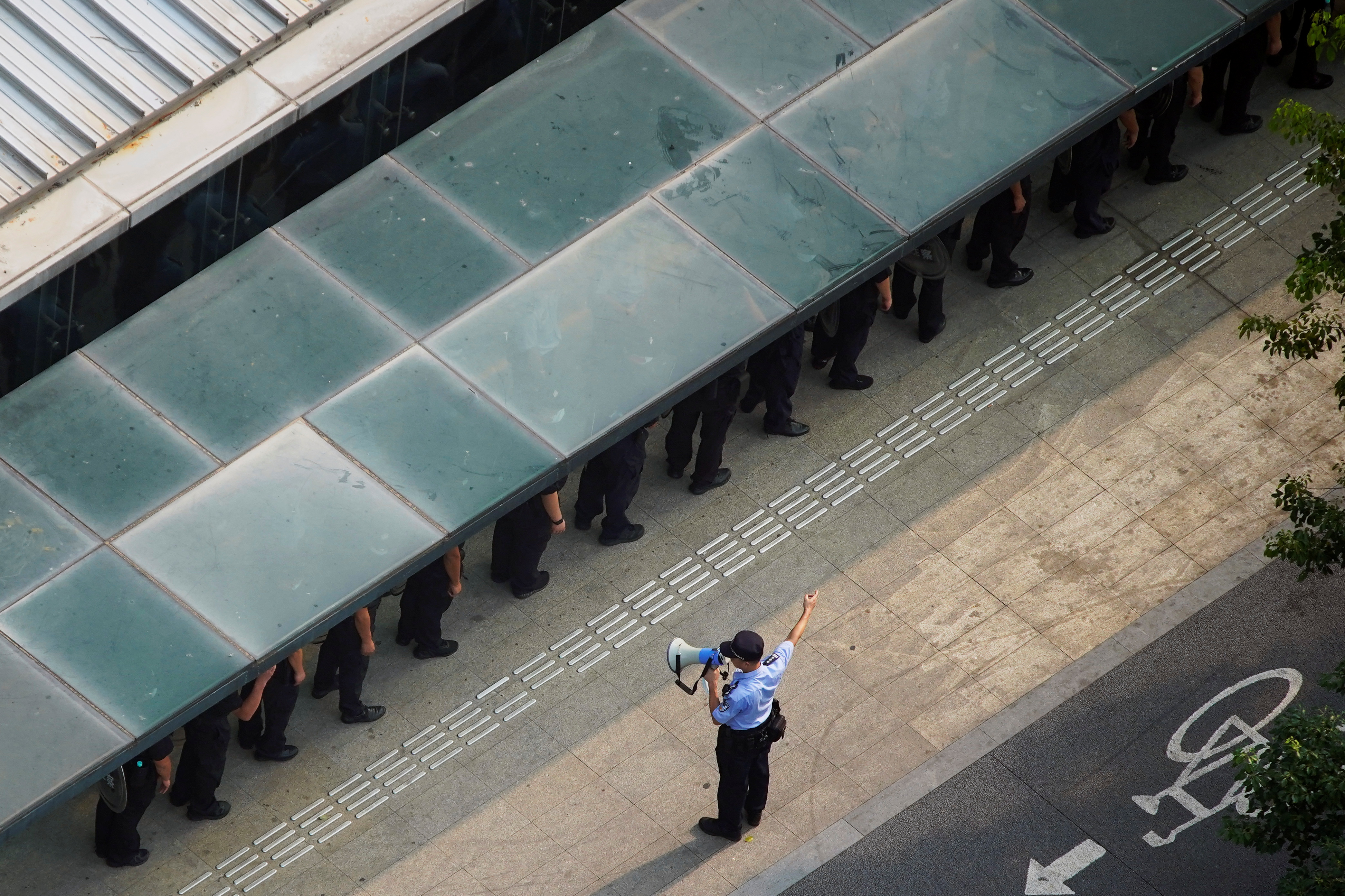 A police officer instructs security personnel outside the headquarters of China Evergrande Group in Shenzhen, Guangdong province, China, September 30, 2021. REUTERS/Aly Song