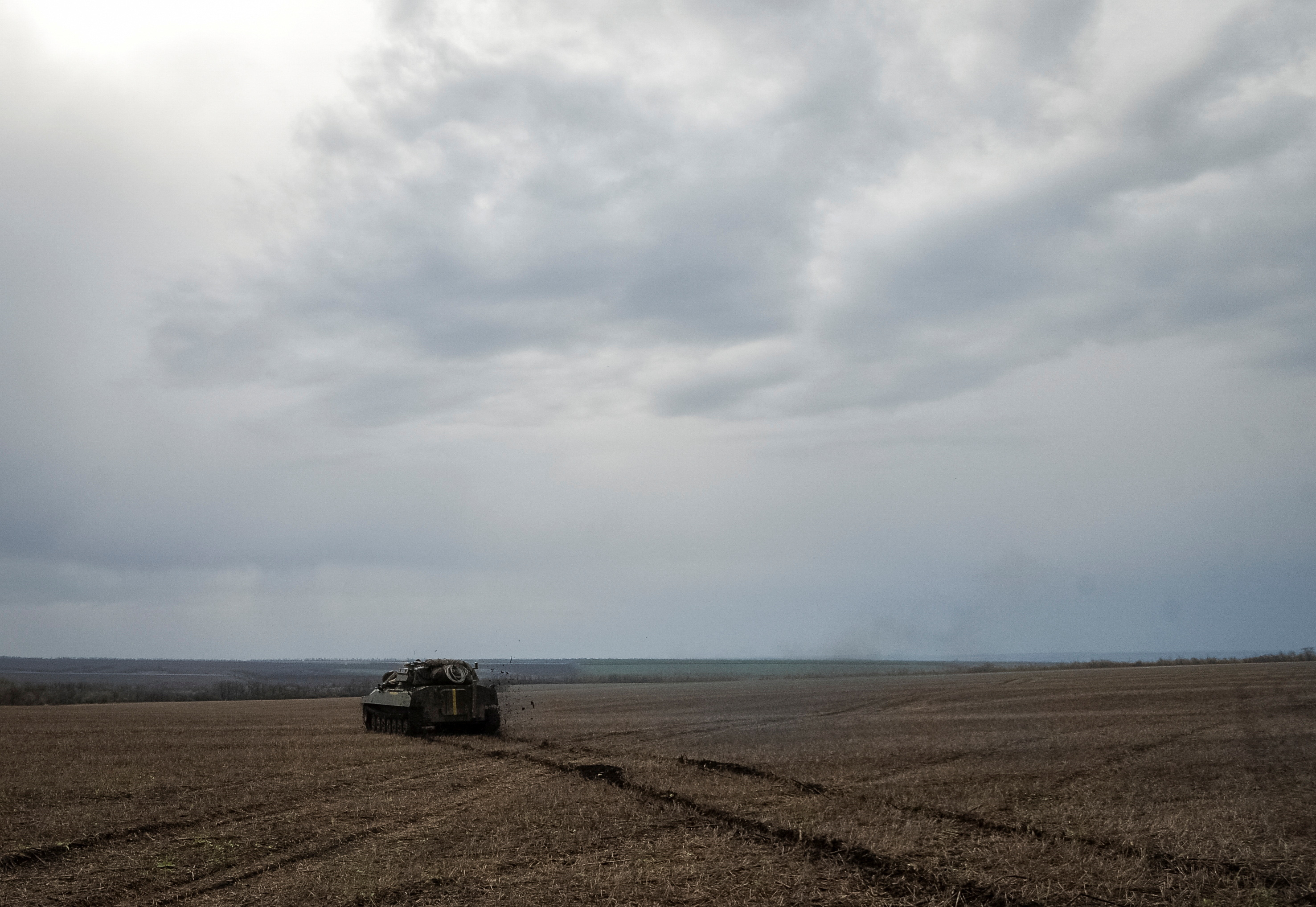 Ukrainian service members ride a self-propelled howitzer near the front line town of Bakhmut