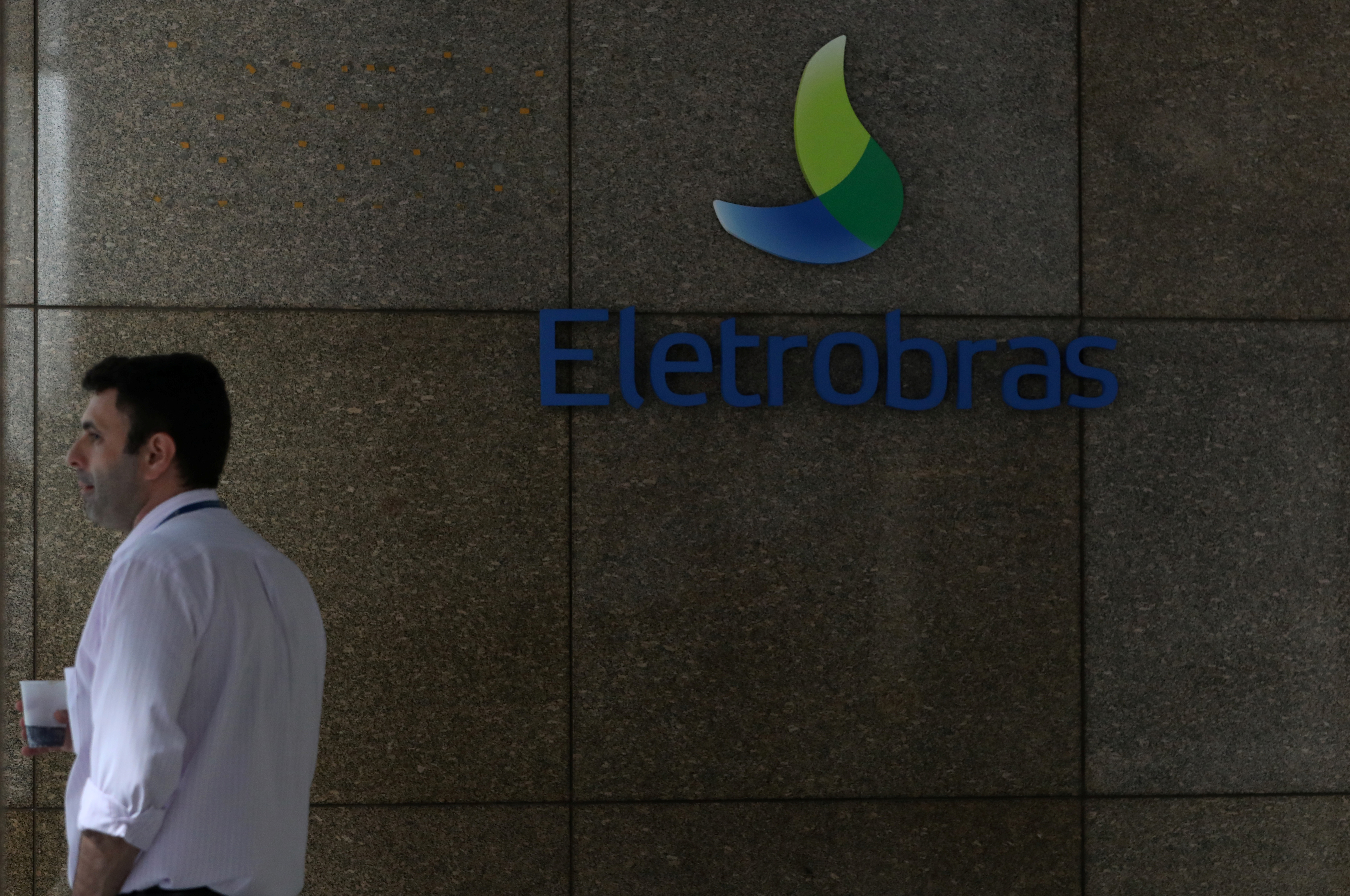 A person stands next to the logo of Brazil's power company Eletrobras in Rio de Janeiro