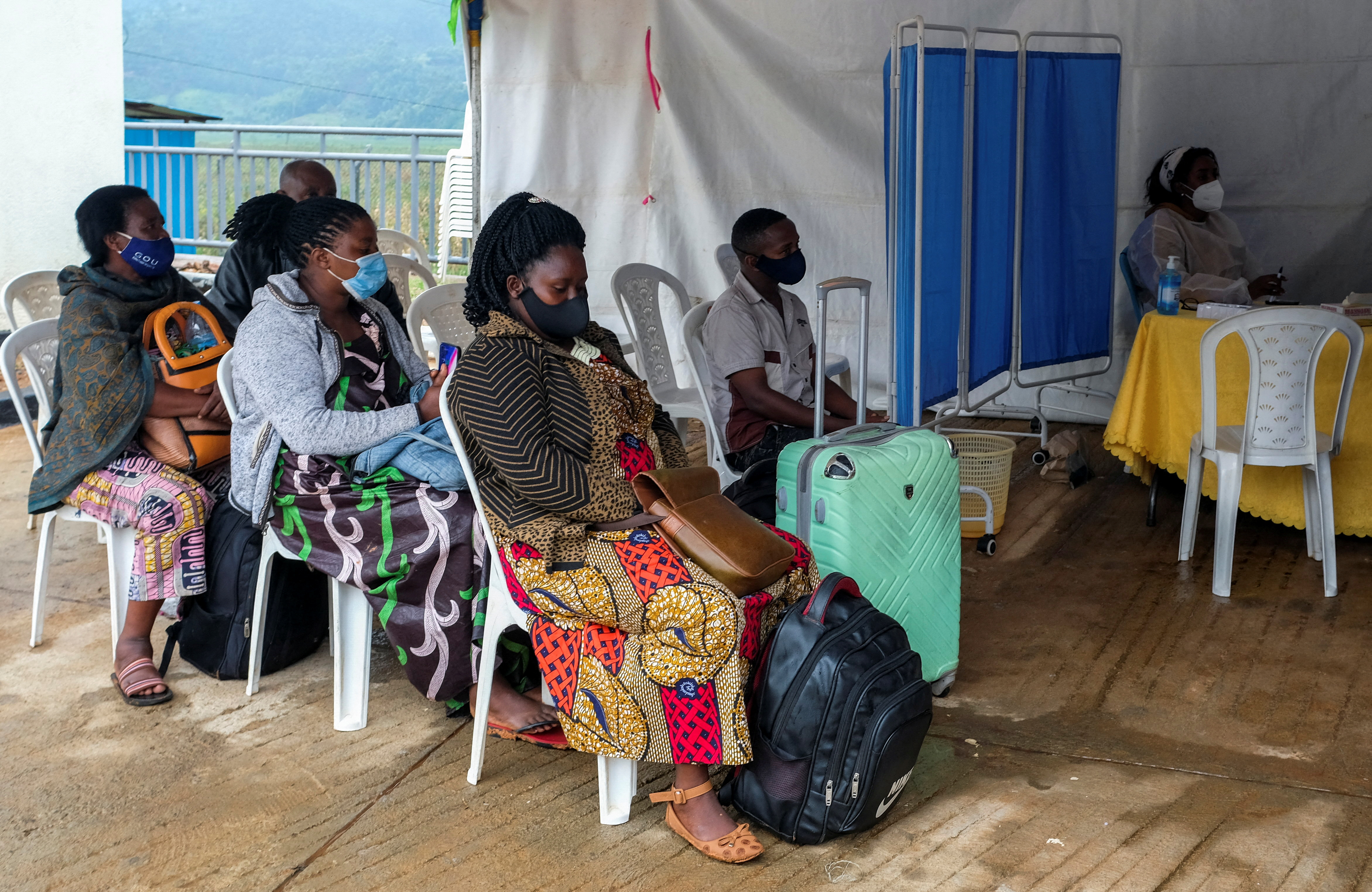 Travellers sit at the health port as they wait for a COVID-19 test at the Gatuna one-stop border post at Gicumbi