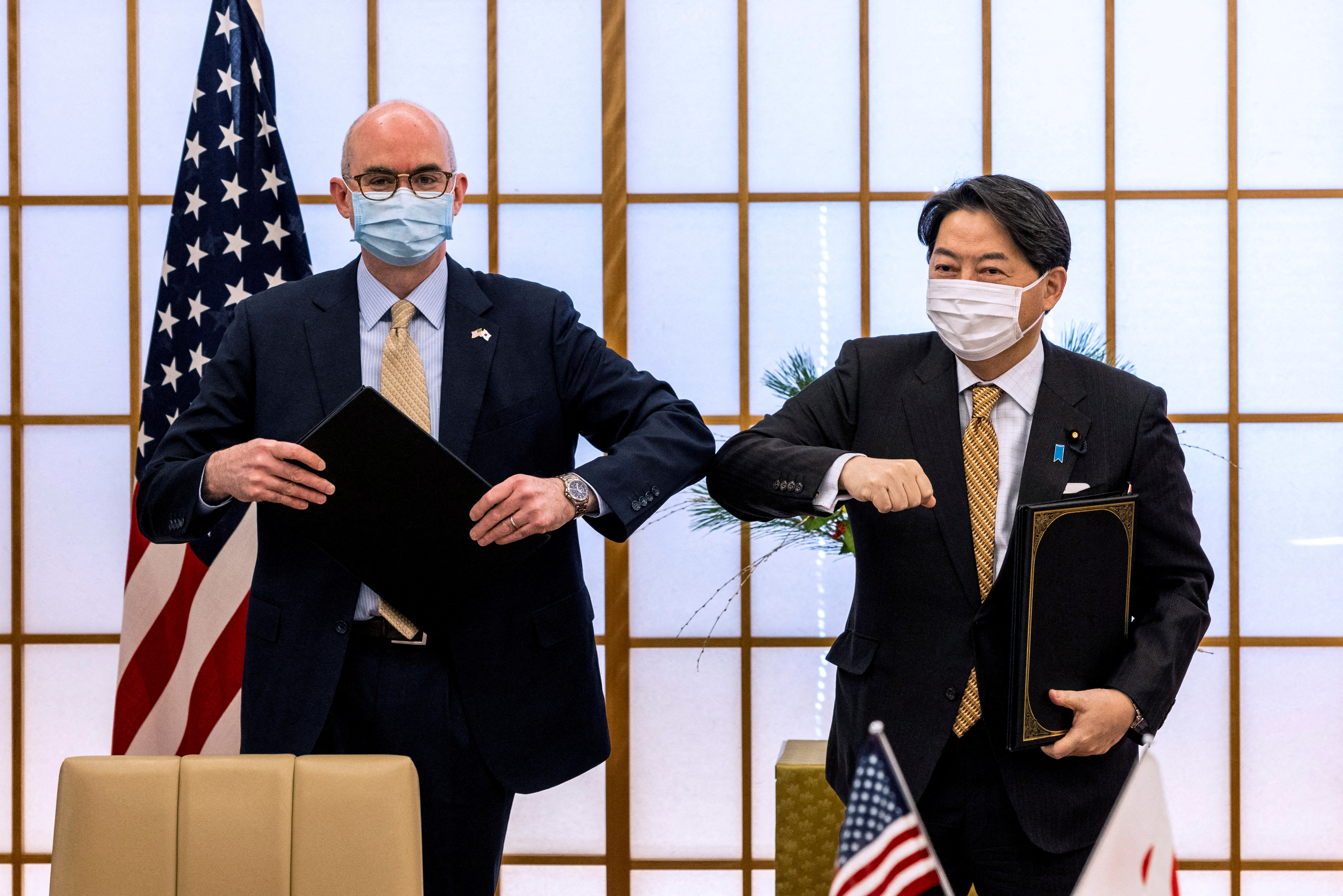 Japan's Foreign Minister Yoshimasa Hayashi and Raymond F. Greene, charge d'affairs ad interim of the U.S. embassy in Japan bump elbows after signing the New Special Measures Agreement (SMA) and Japan-U.S. Joint Research in Tokyo