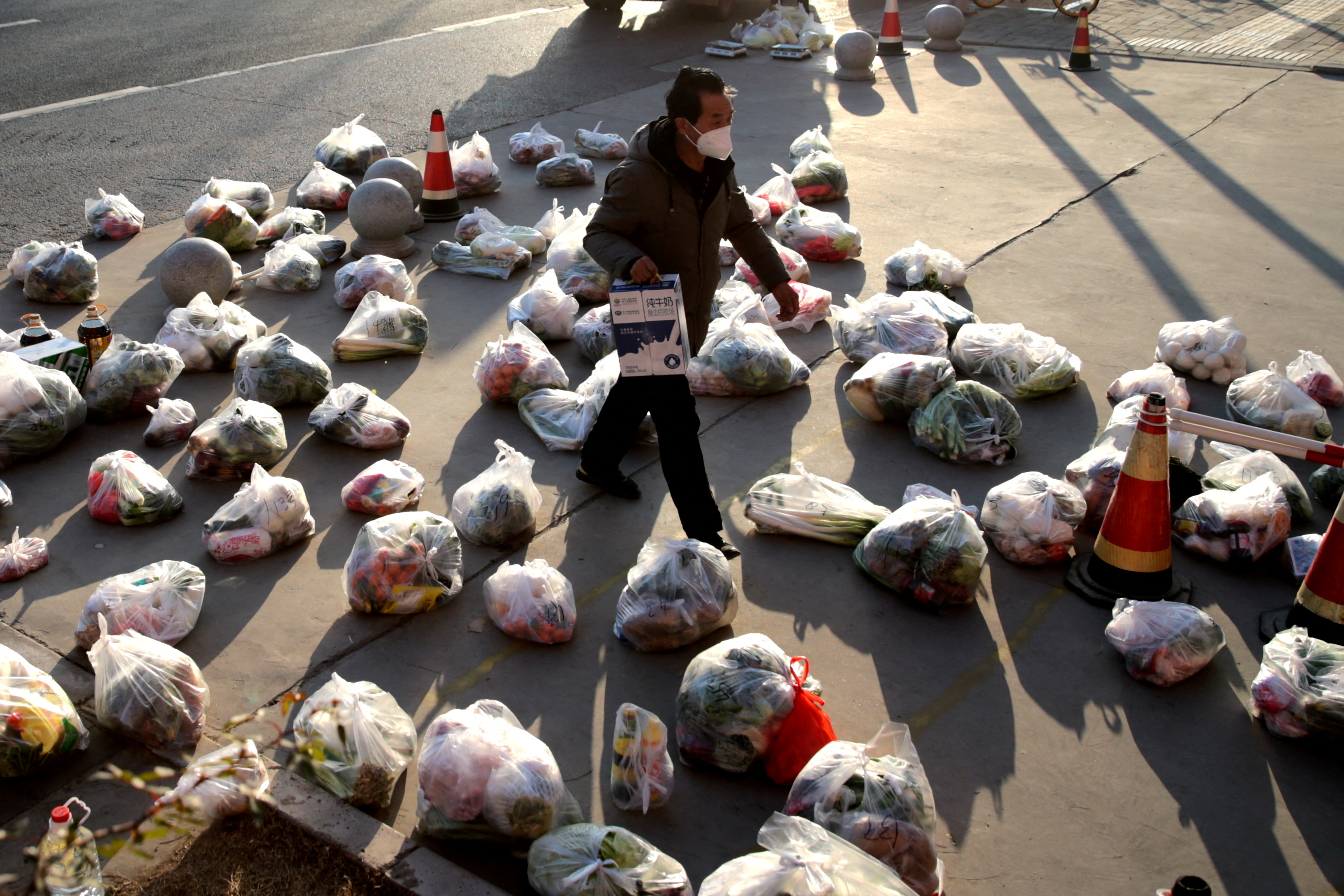 Worker prepares food supplies to be delivered to residents of a residential compound under lockdown in Xian