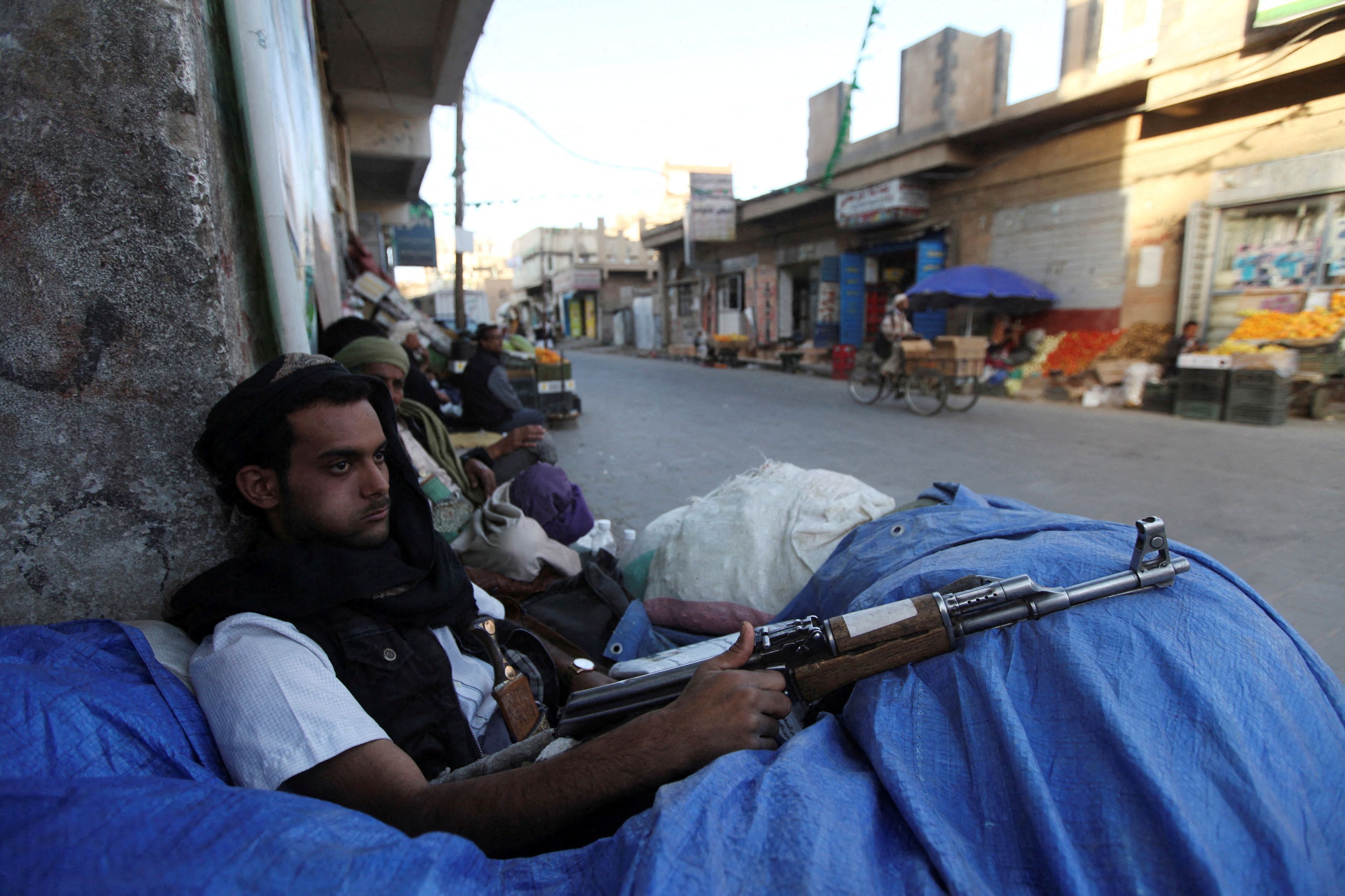 FILE PHOTO: A Shi'ite Houthi fighter sits behind sandbags near a checkpoint in Sanaa