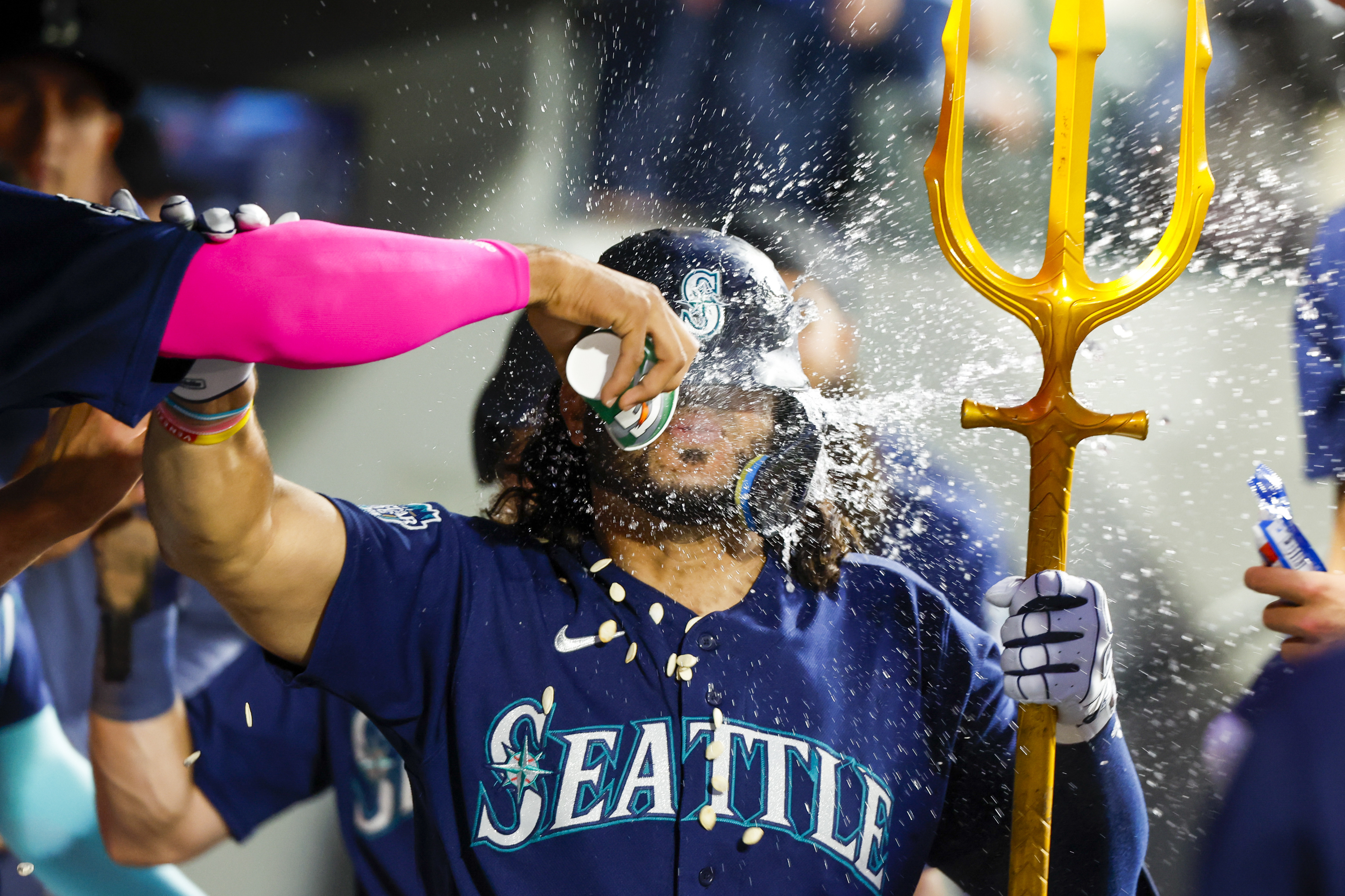 Seattle Mariners' Eugenio Suarez holds a trident while celebrating