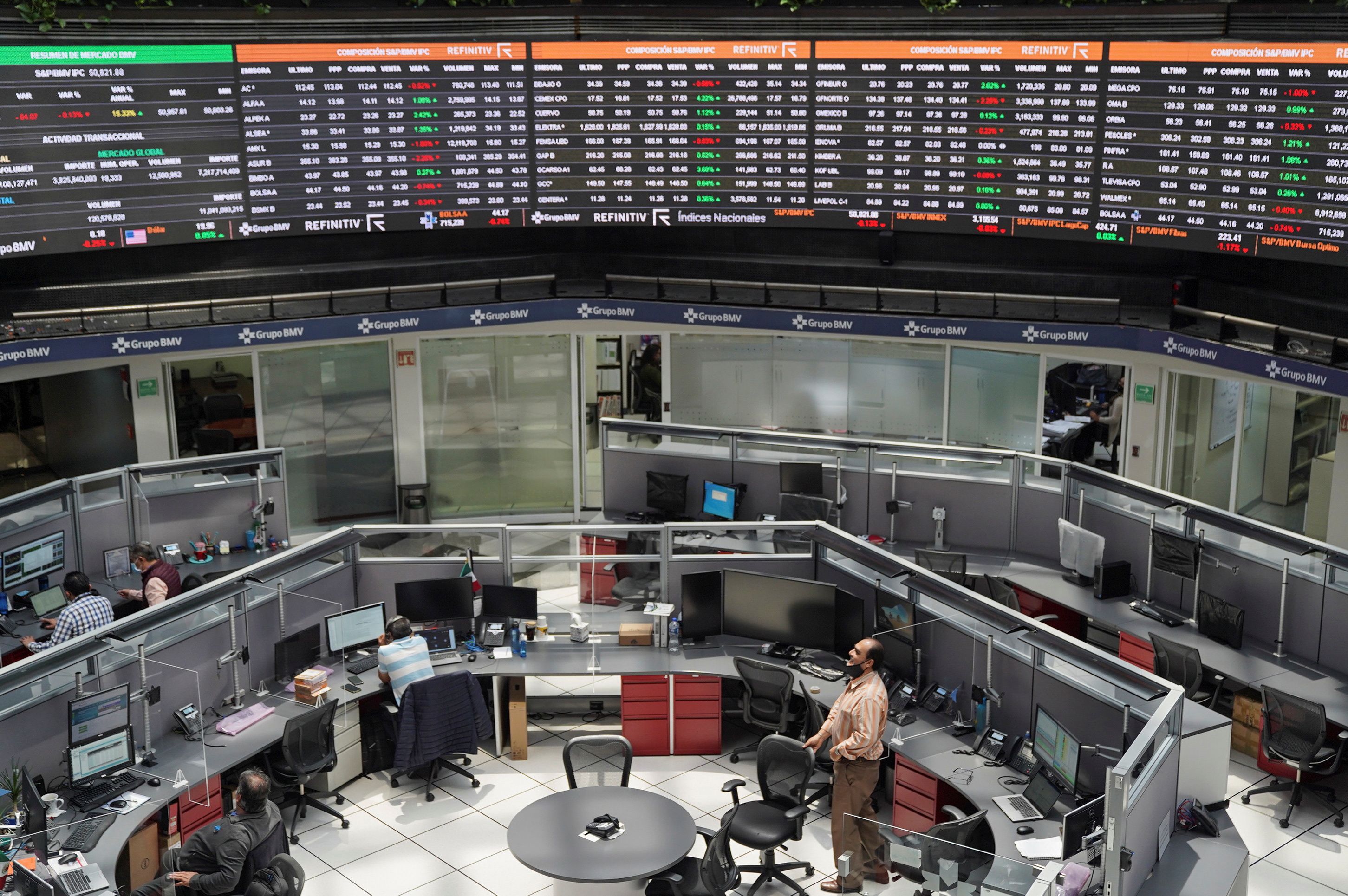 Employees work at their positions as a ticker displays stock exchange data at Mexico's stock exchange, in Mexico City