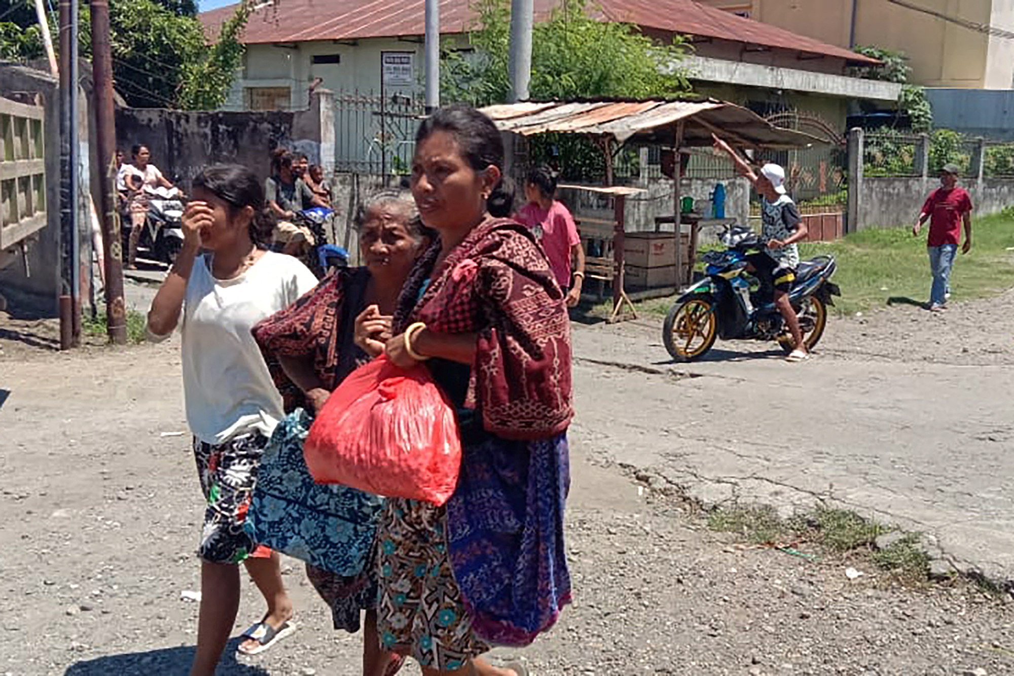 Women are seen evacuating, as a 7.4-magnitude earthquake struck eastern Indonesia triggering a tsunami warning in Maumere, East Nusa Tenggara, Indonesia, December 14, 2021. Antara Foto/Siska via REUTERS. 